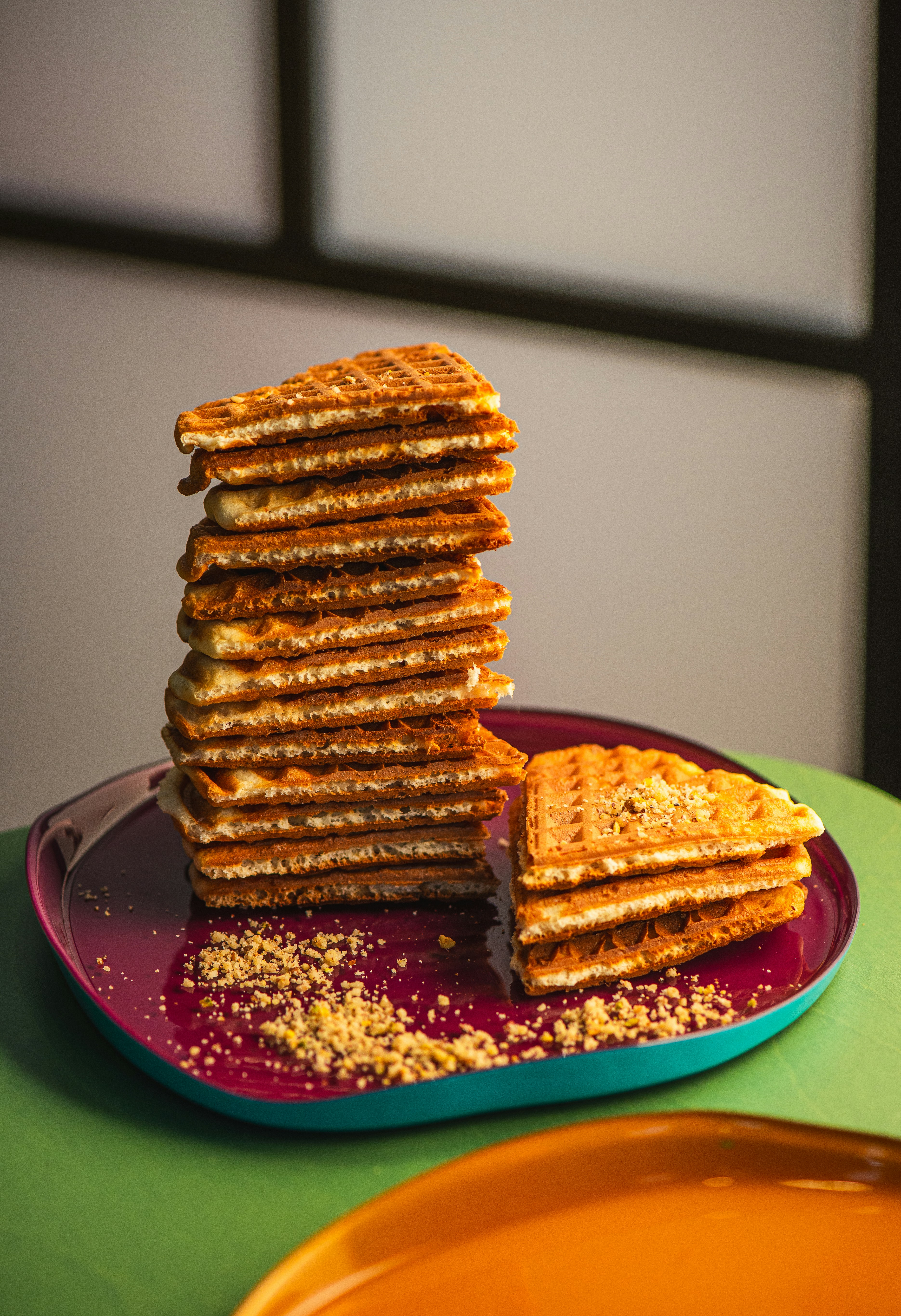 Stack of waffles with crumbs on a plate