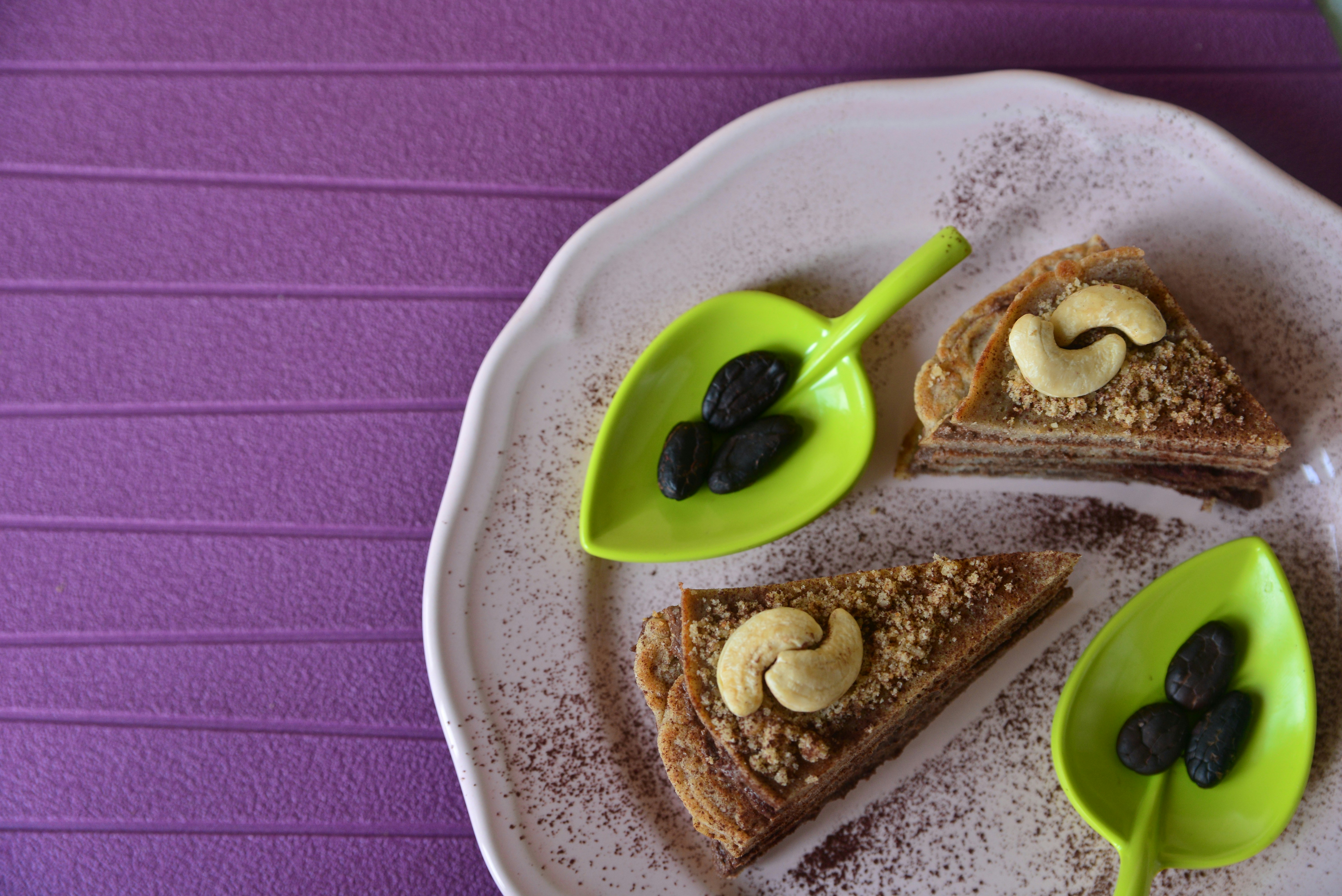 Two slices of dessert with cashews and nuts.