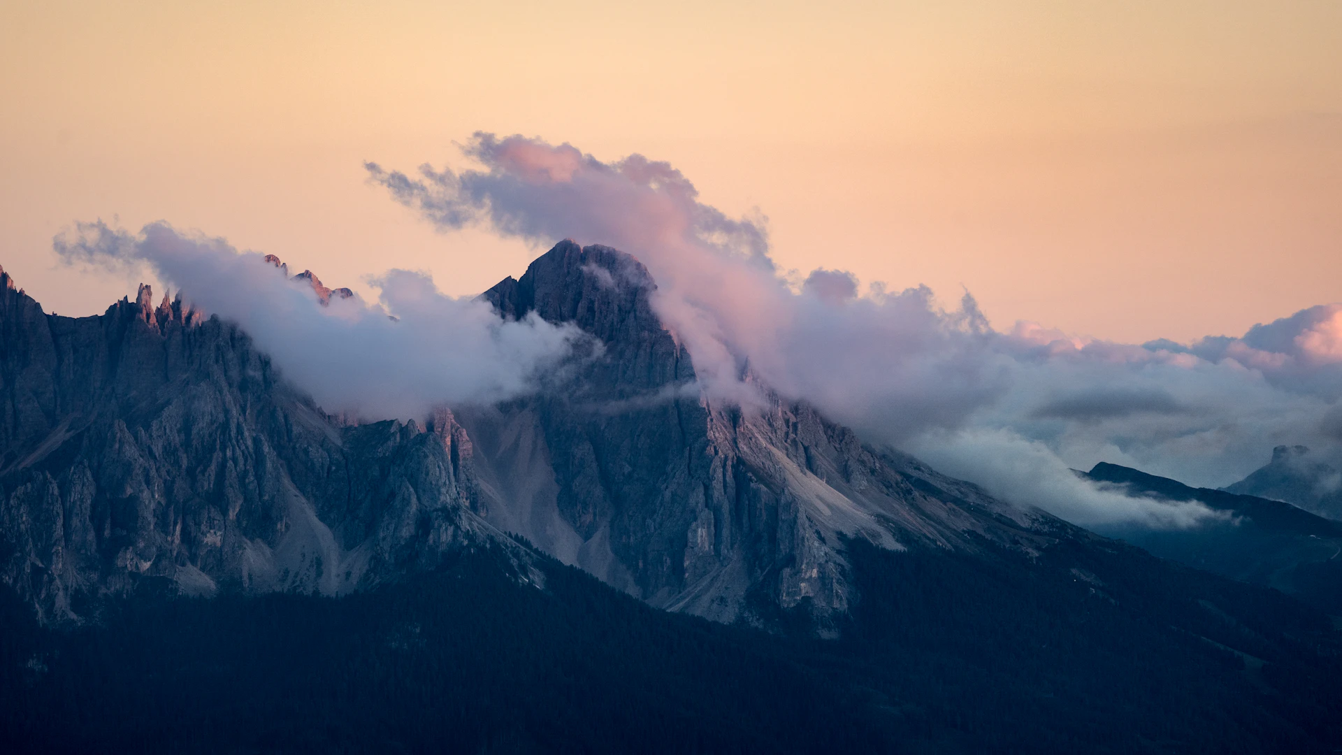 Misty mountain peaks at sunrise with soft pastel sky