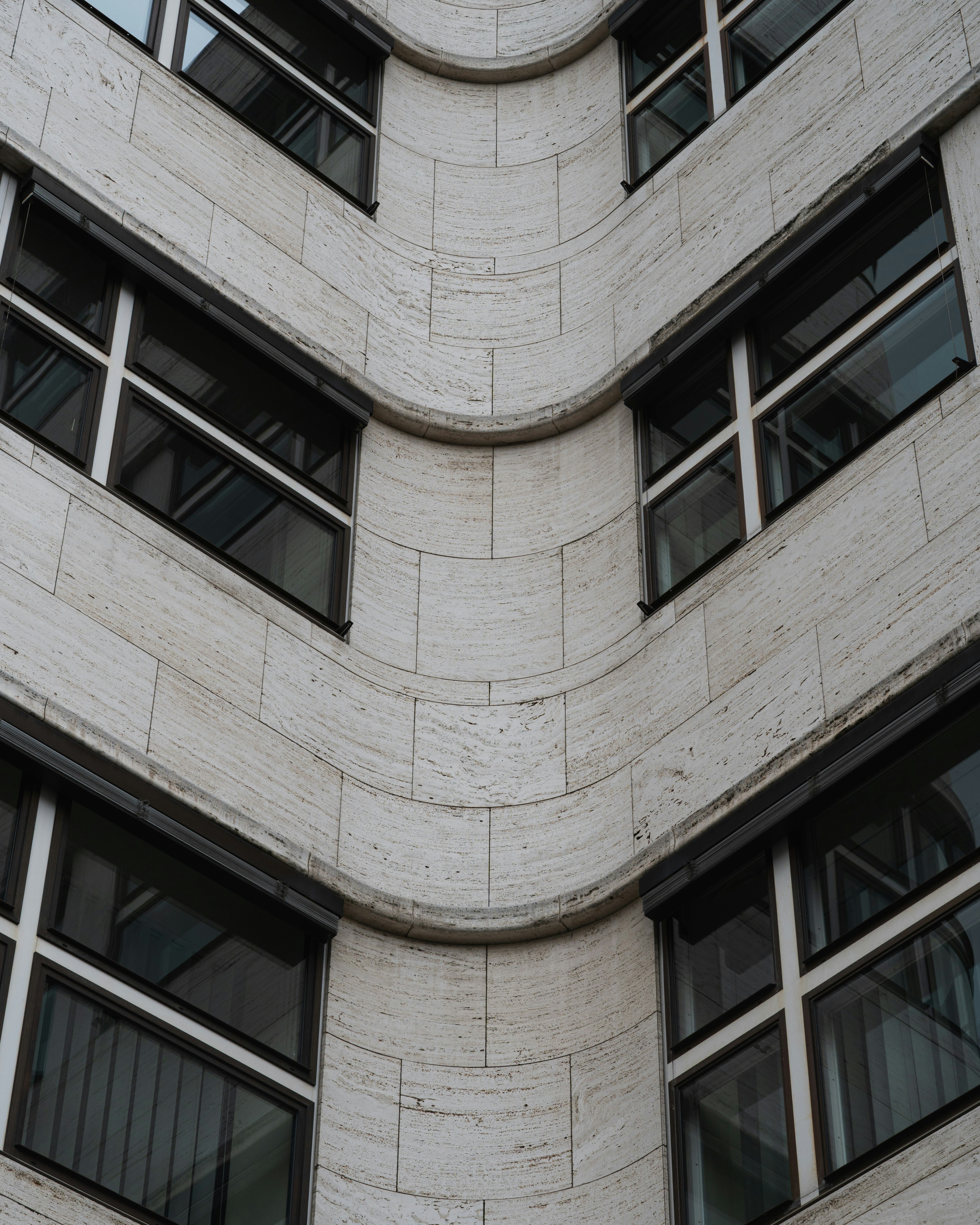 Curved concrete building facade with repeating windows.