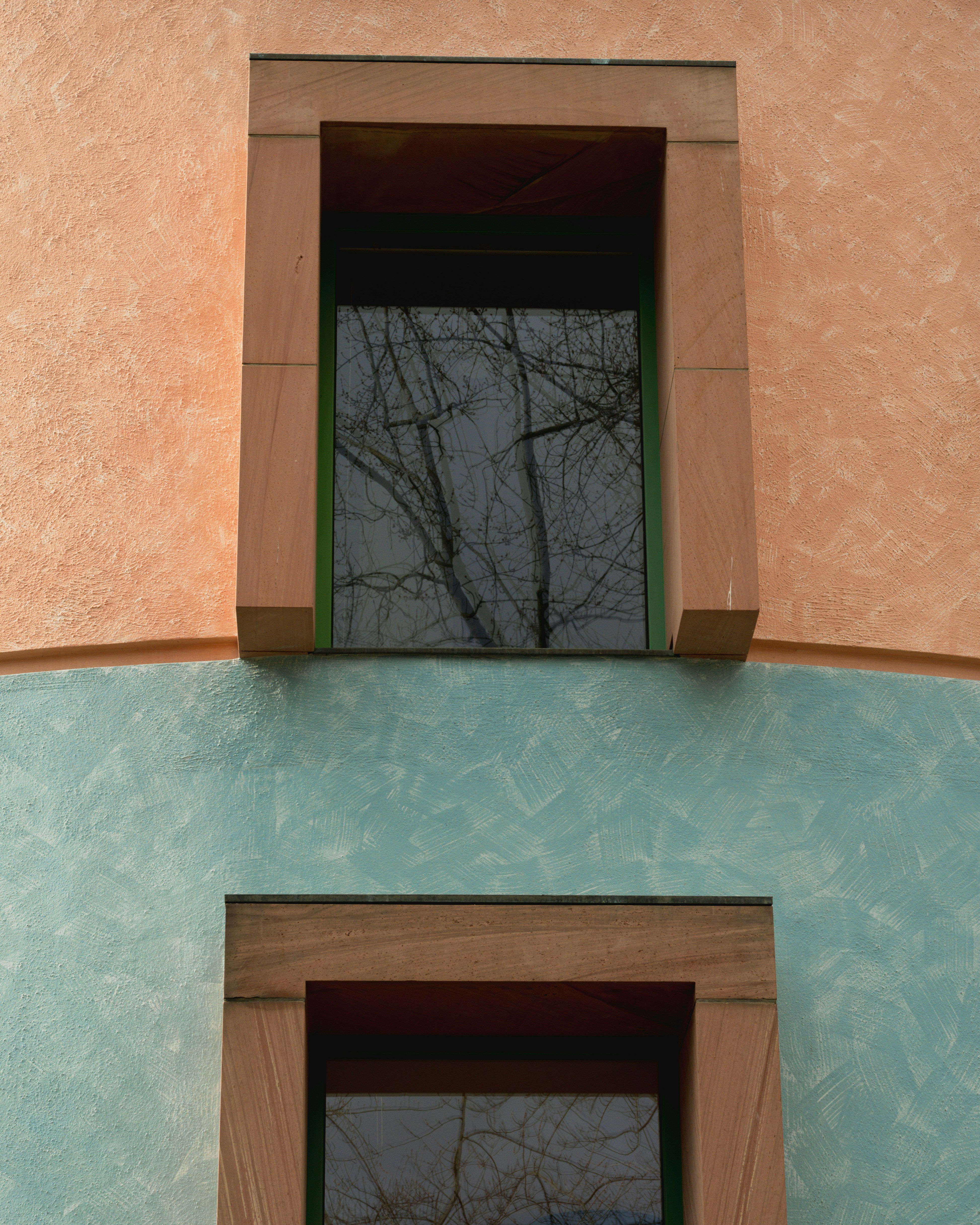 Two windows on a textured wall