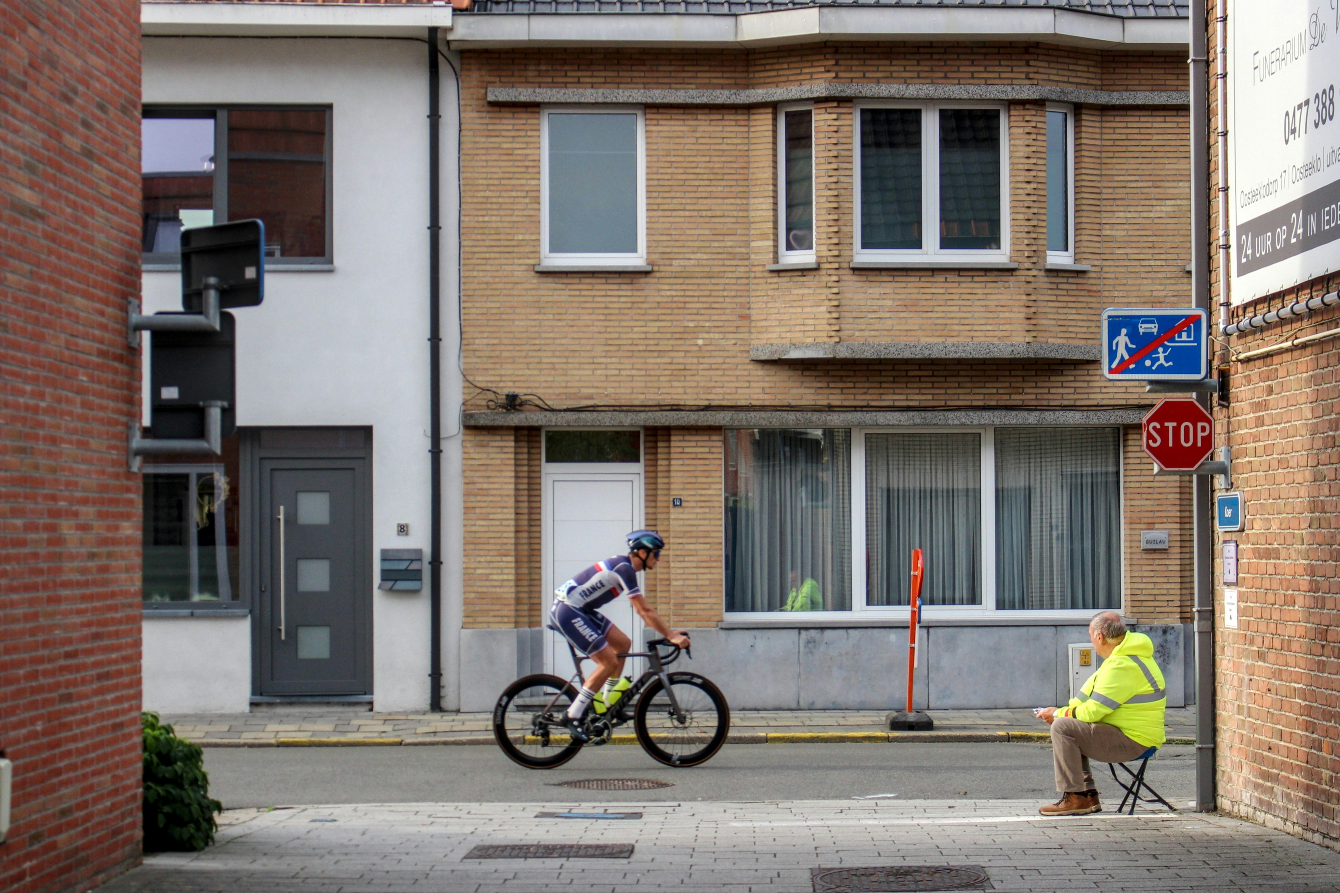 Cyclist passes a spectator on a street.