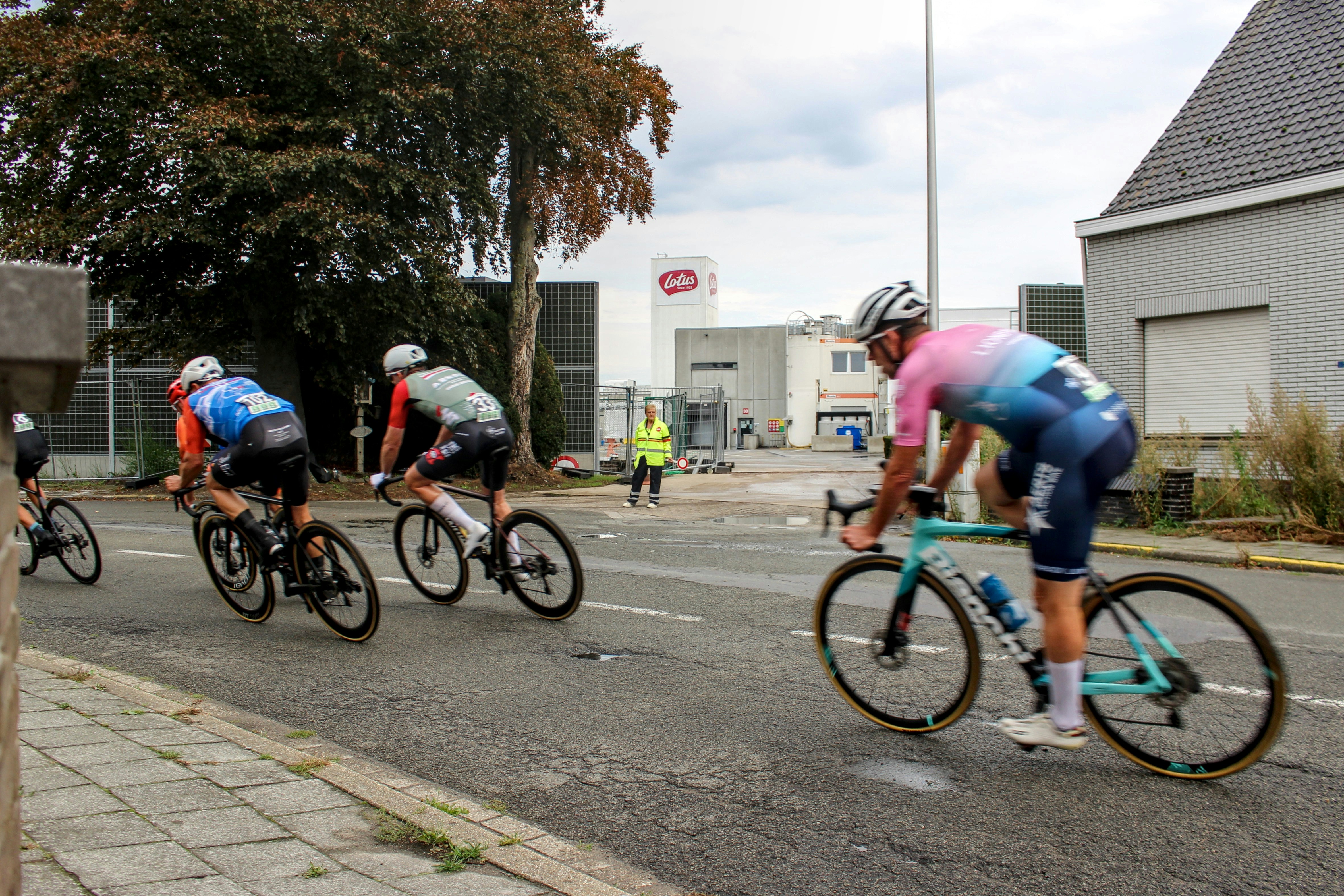 Cyclists racing on a paved road with buildings nearby