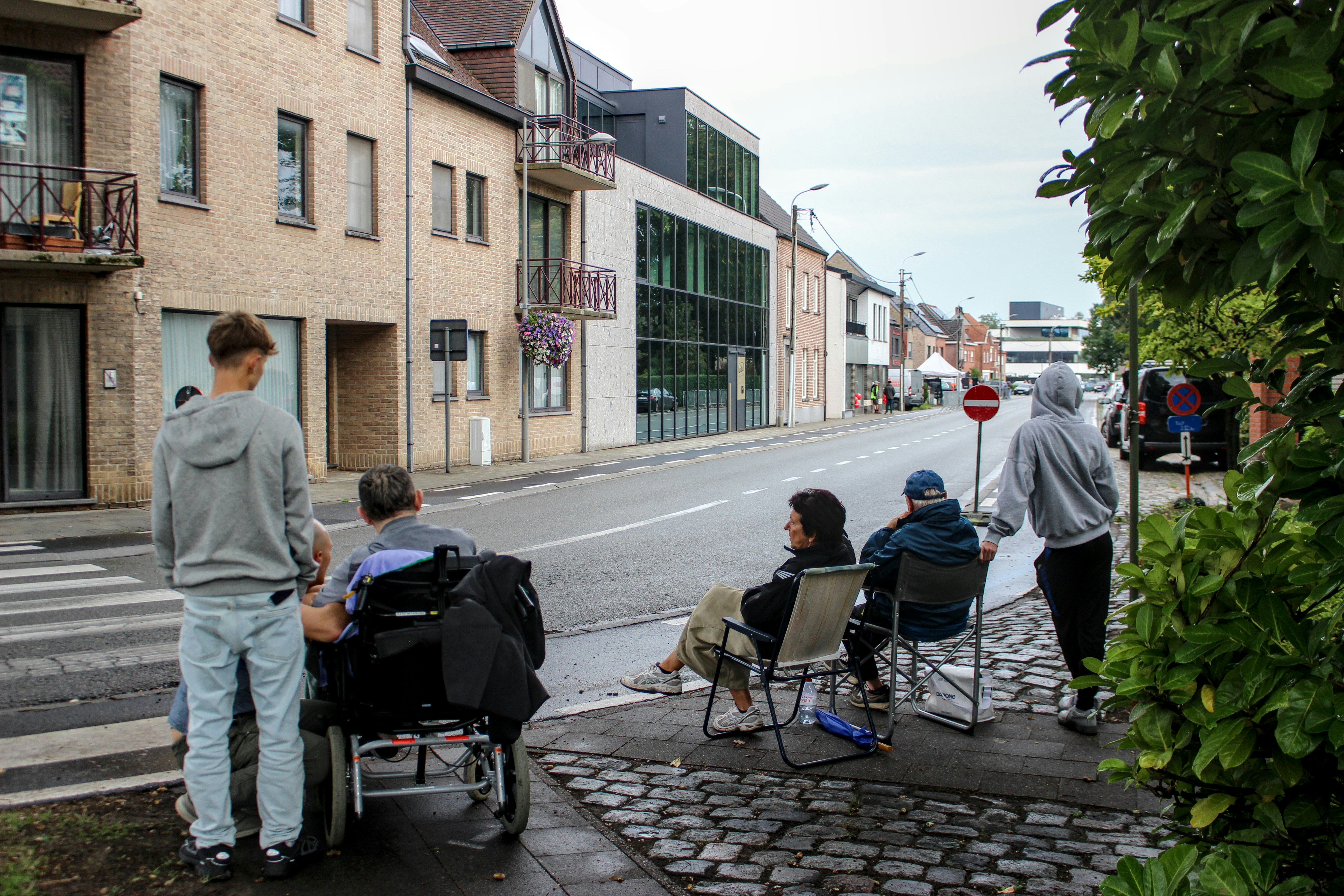 Menschen, die an einer Straßenecke sitzen und stehen