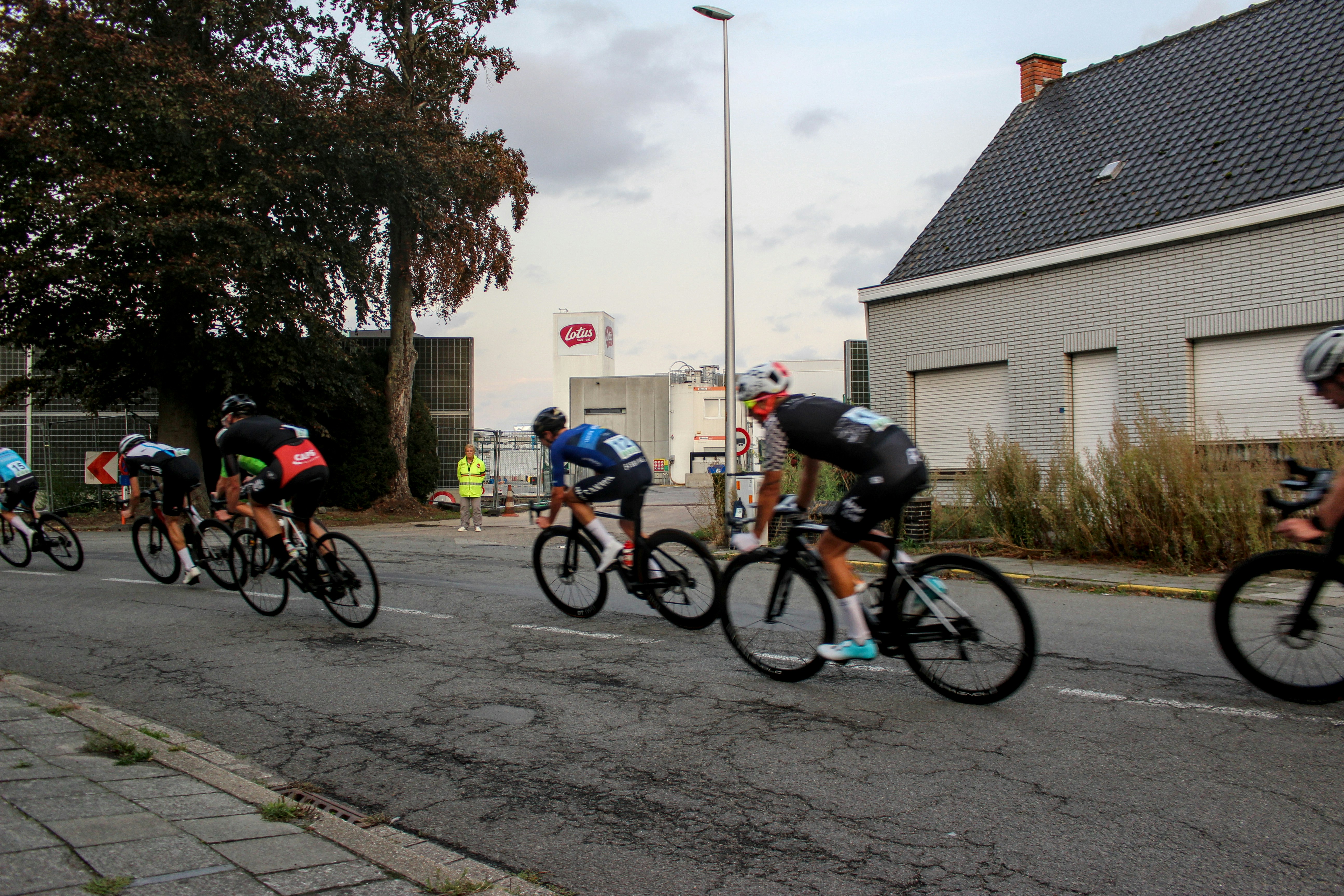 Cyclists racing on a paved road during daytime.
