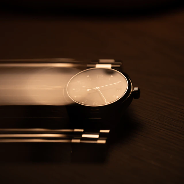 A wristwatch caught with motion blur on a dark surface