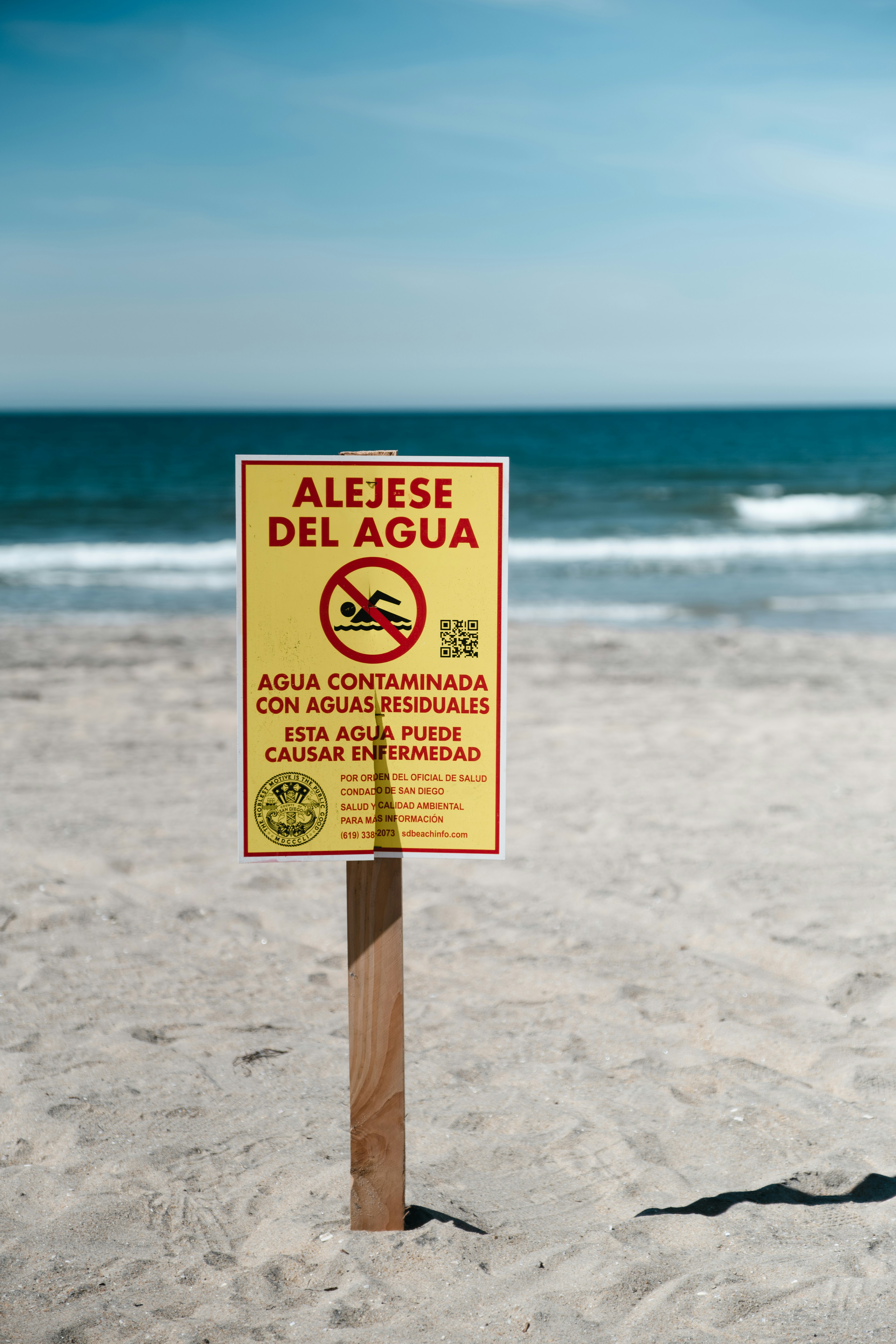 Señal de advertencia en la playa sobre agua contaminada