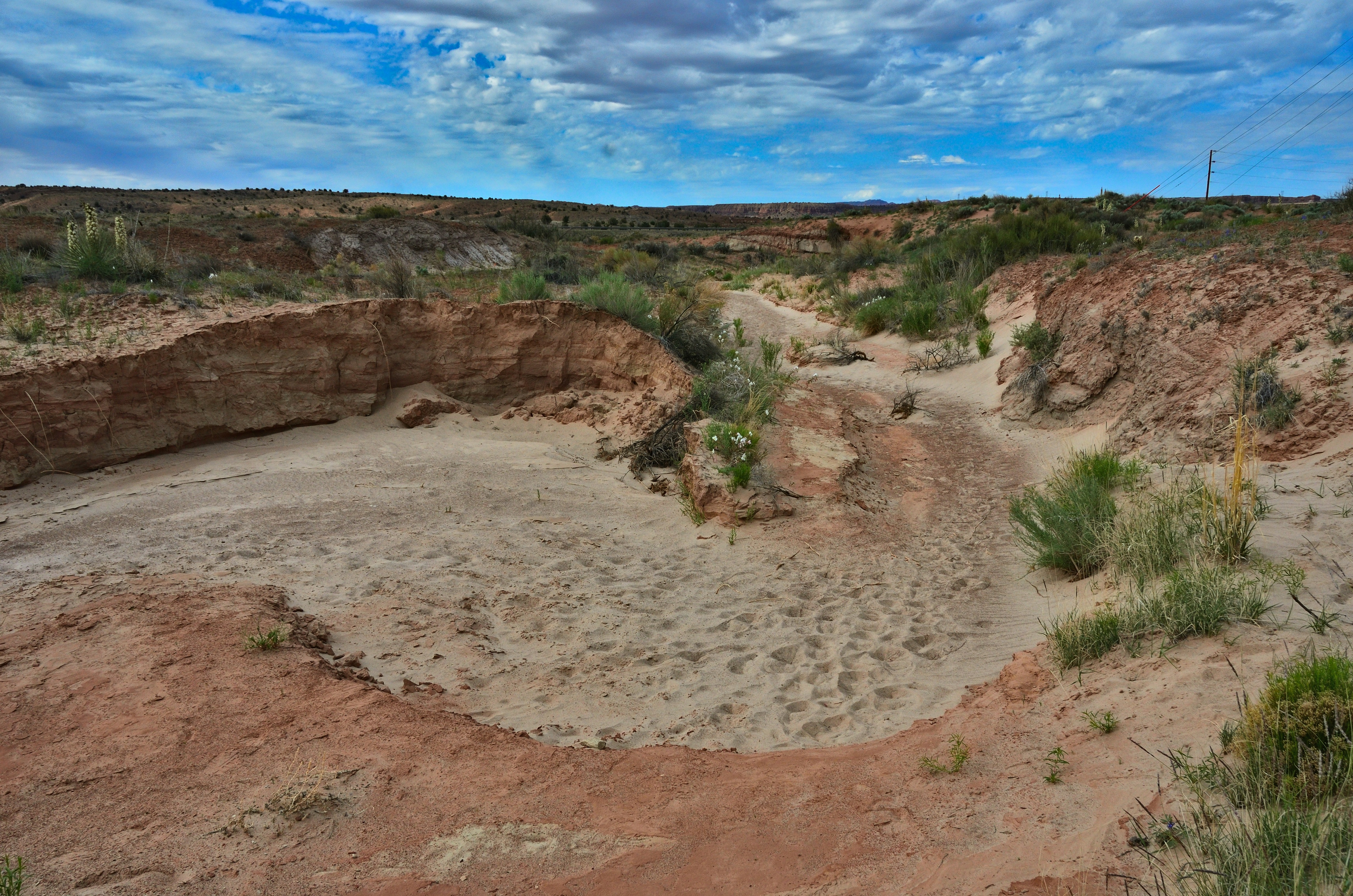 Arid landscape with sandy creek bed and eroded banks