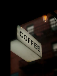 A lit coffee sign at night