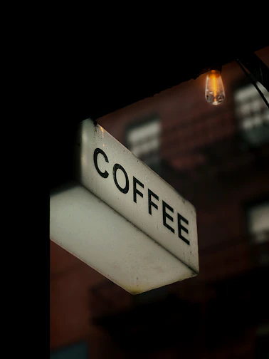 A lit coffee sign at night
