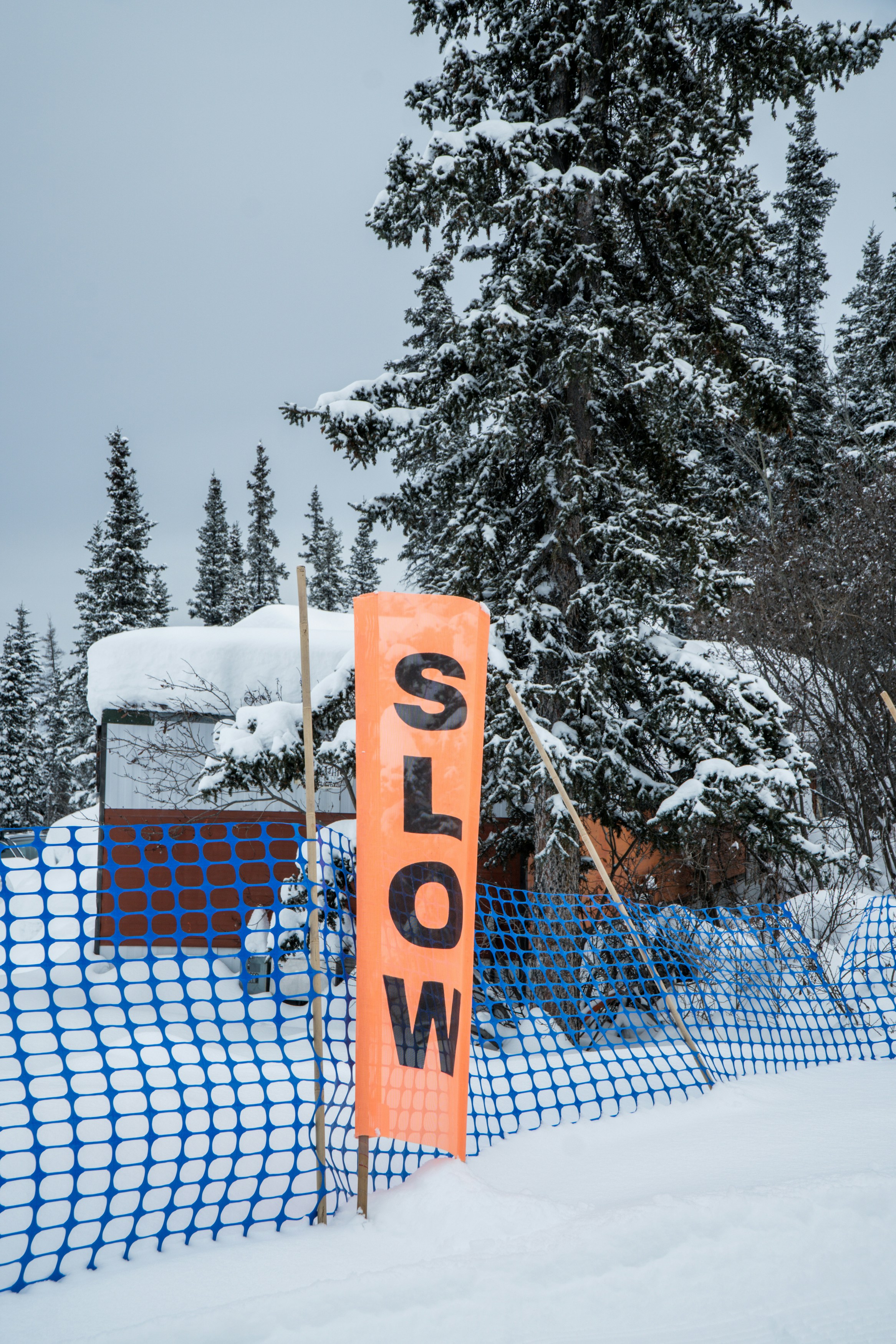 Señal naranja de ralentización en una pista de esquí nevada