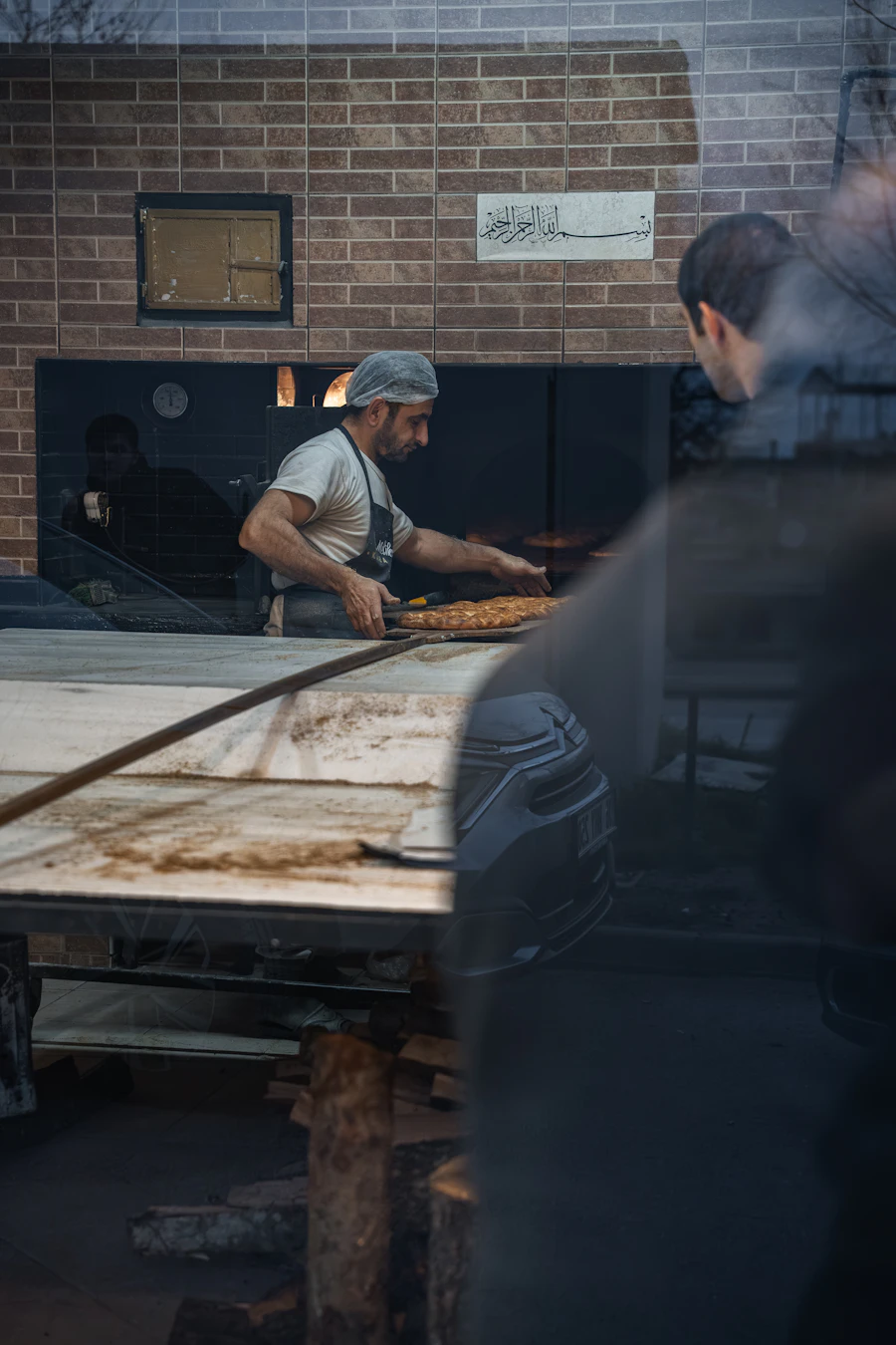 Baker placing bread into a bakery oven