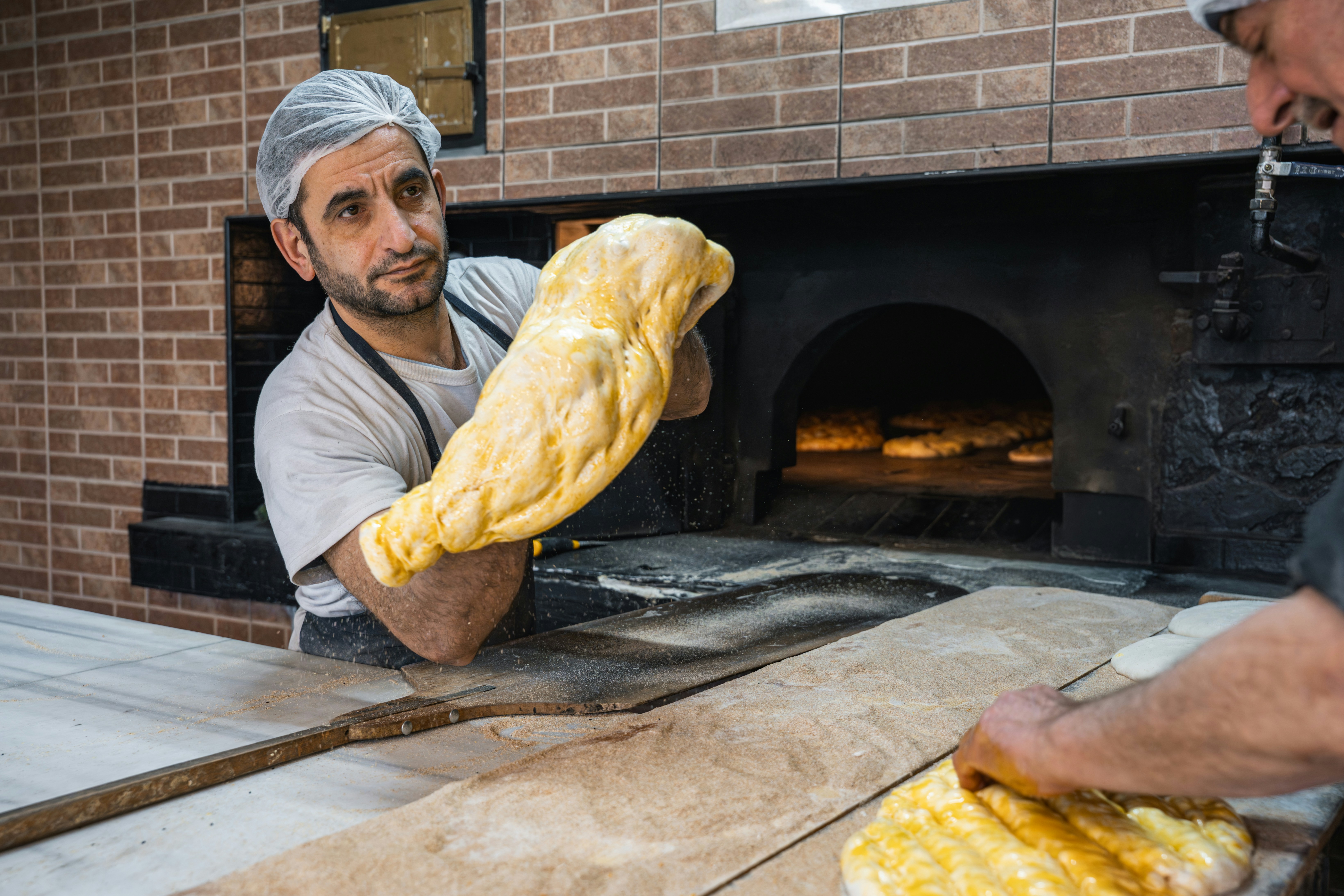 Baker shaping bread dough in the kitchen