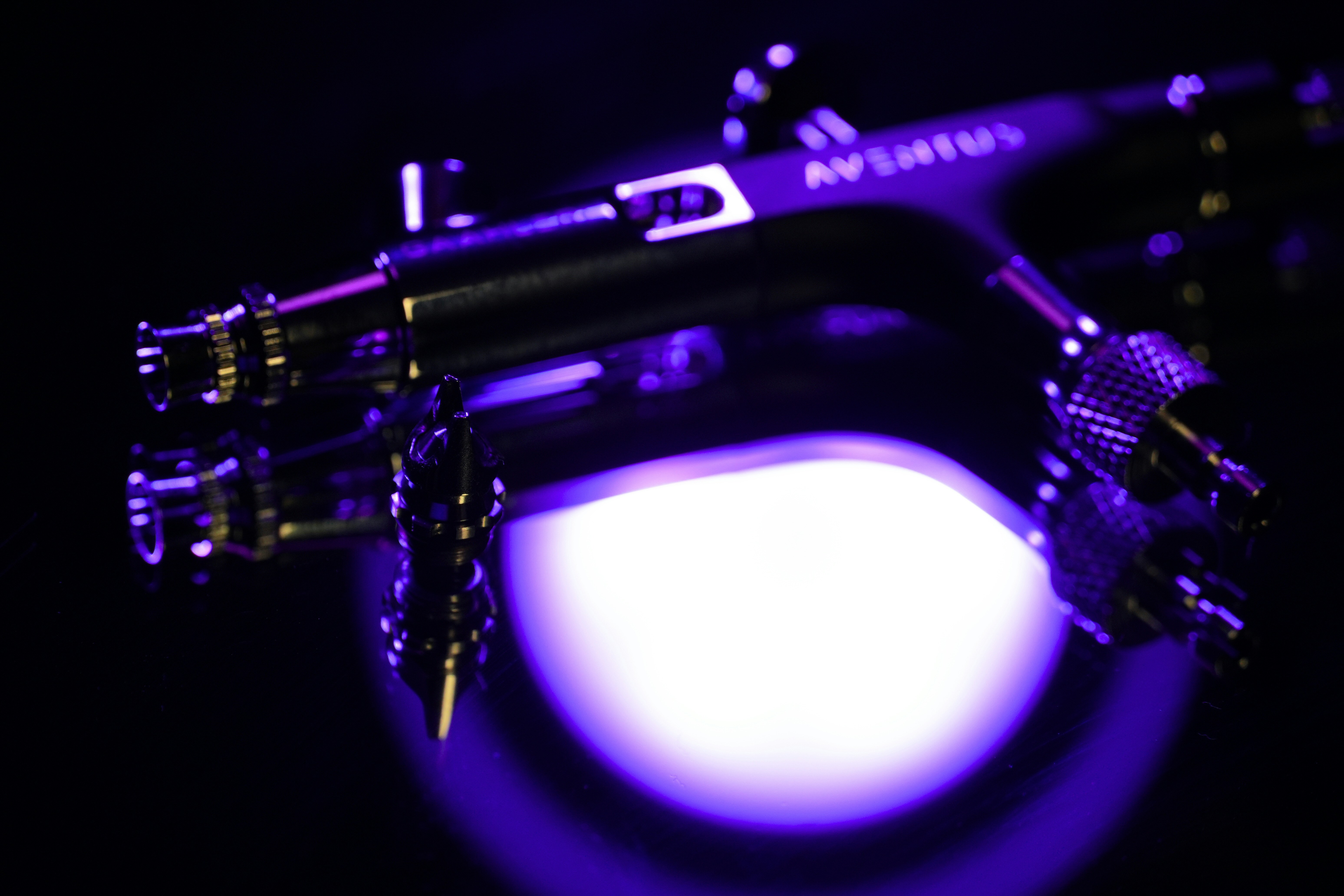 Close-up of a futuristic device with purple light.
