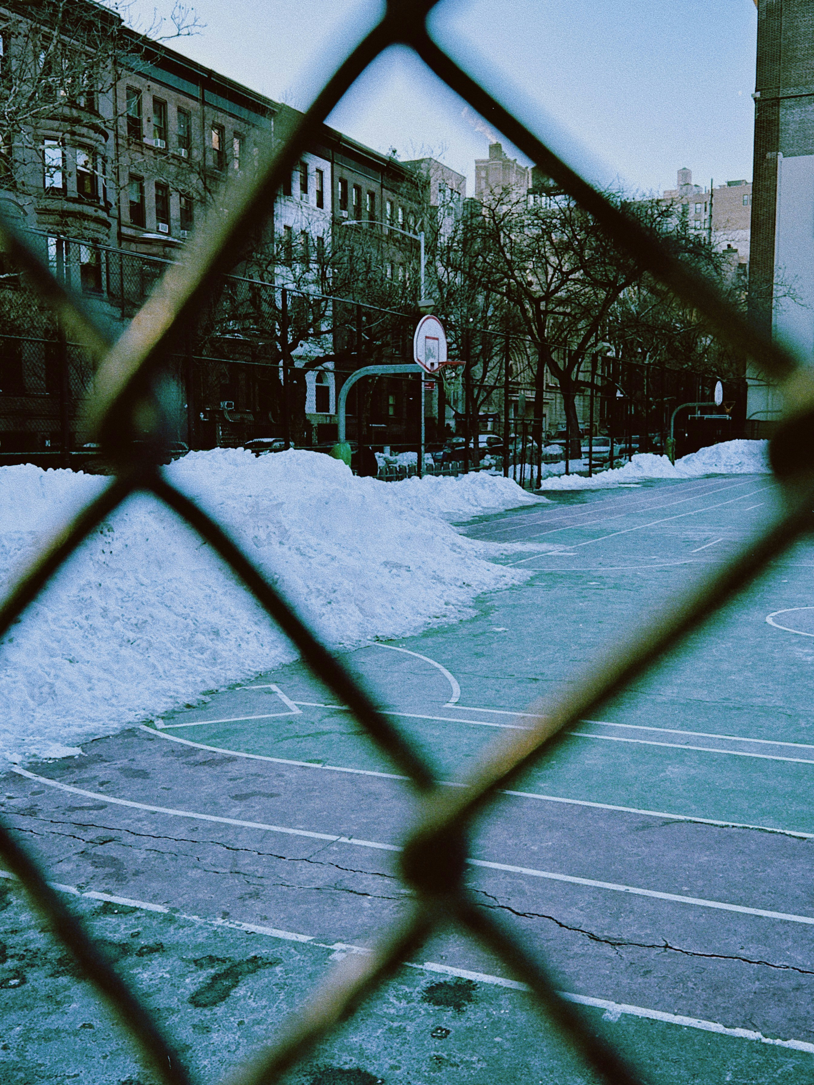 Basketballplatz mit Schnee bedeckt, hinter den Gebäuden