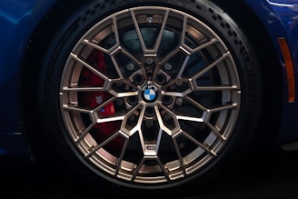 Close-up of a bronze BMW wheel with red brake caliper.