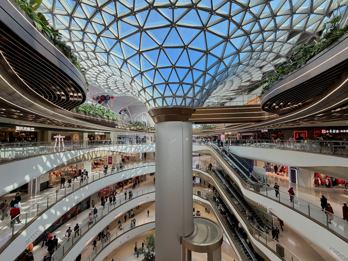 Interior of a modern shopping mall with escalators and shops