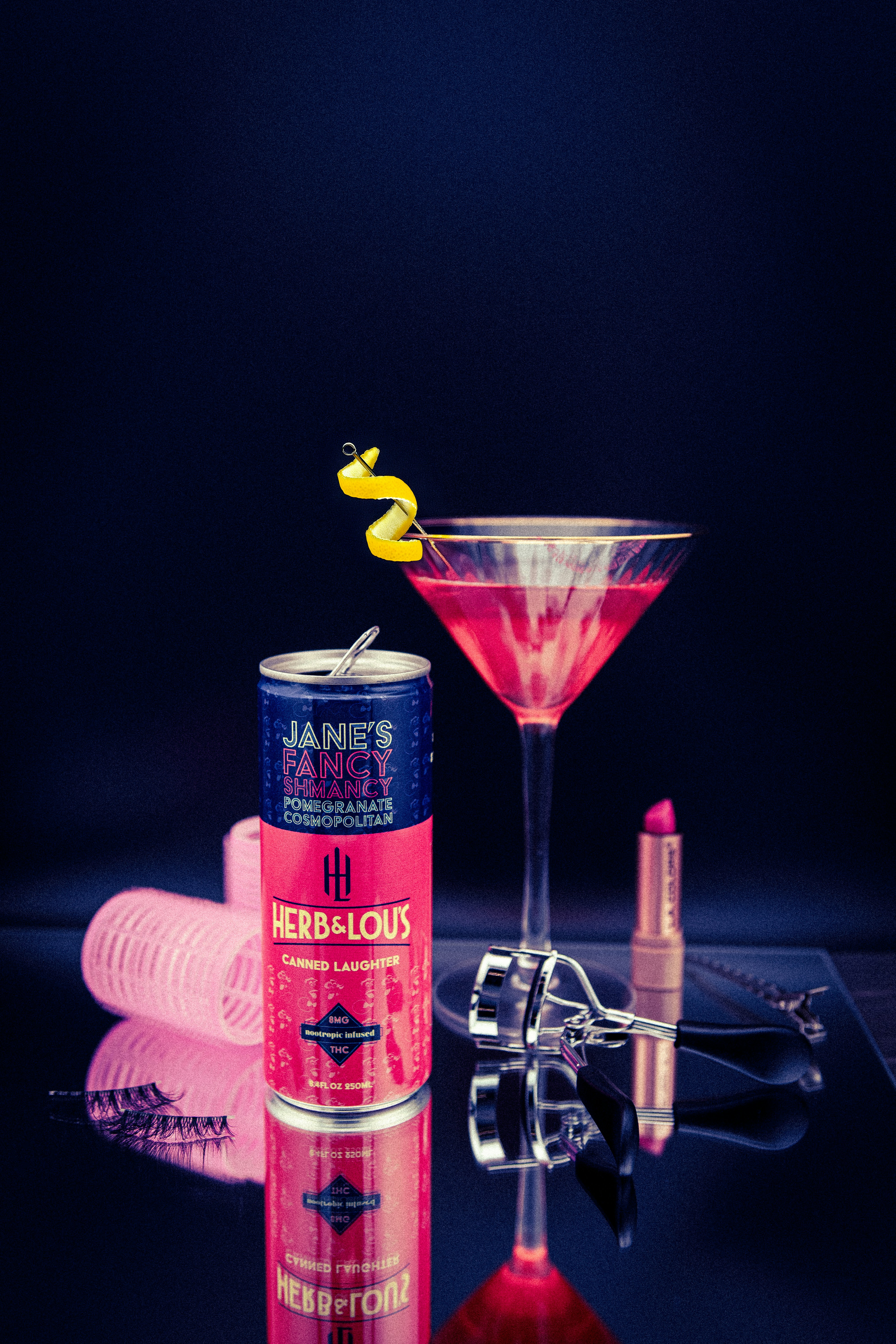 Cosmopolitan cocktail with a can of drink and makeup.
