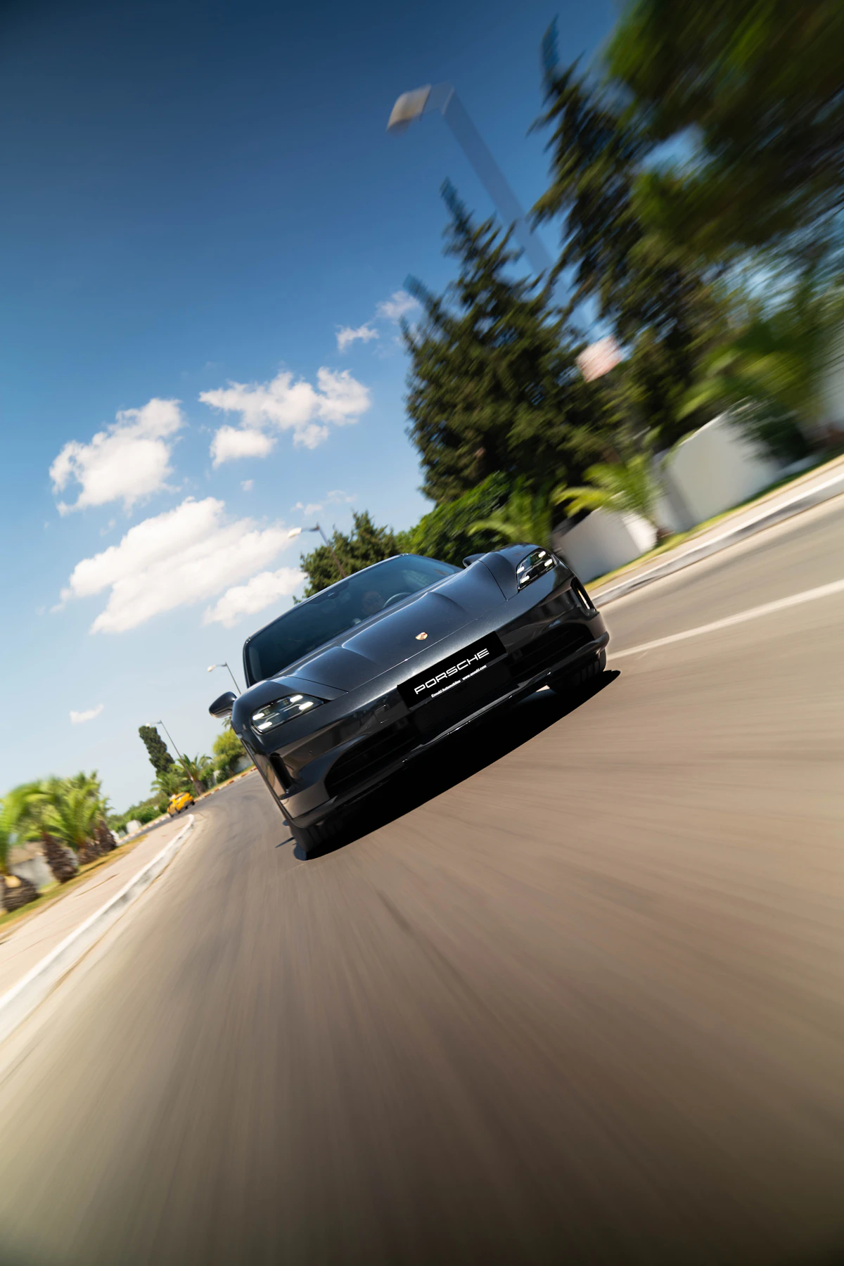 Modern performance car driving quickly on a sunny road