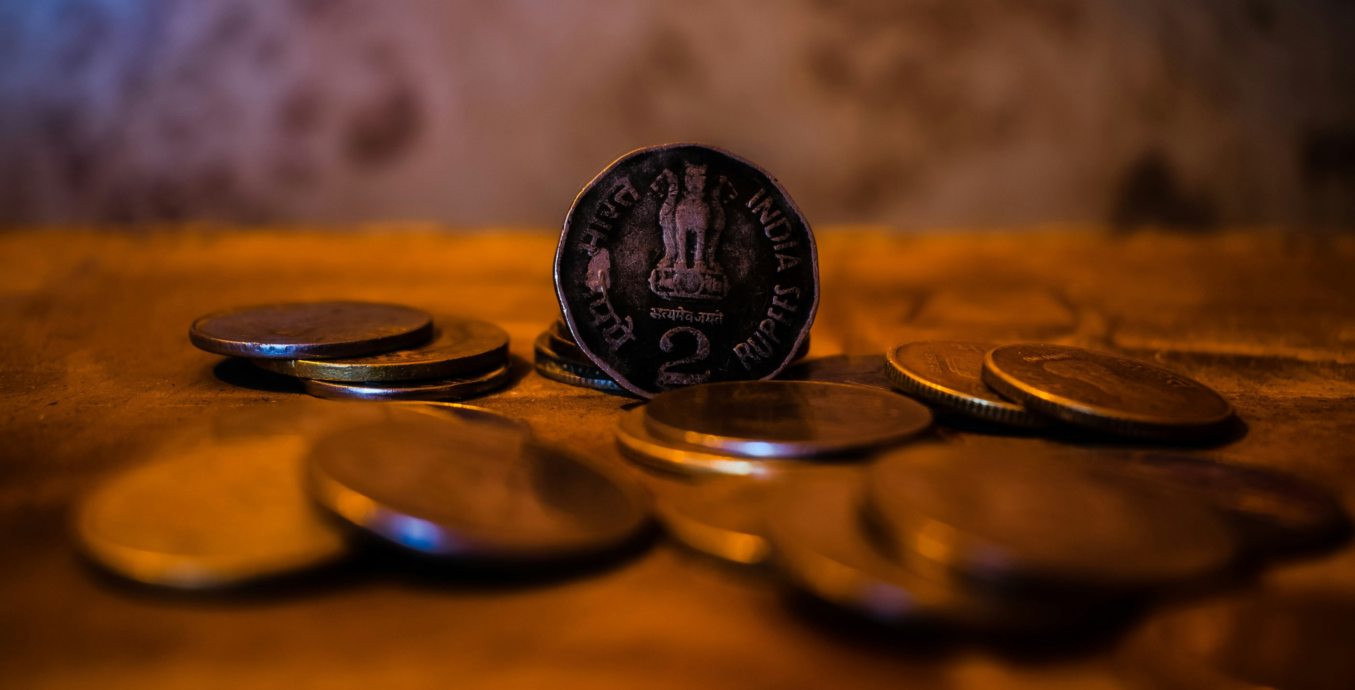 A close-up of indian coins on a wooden surface.