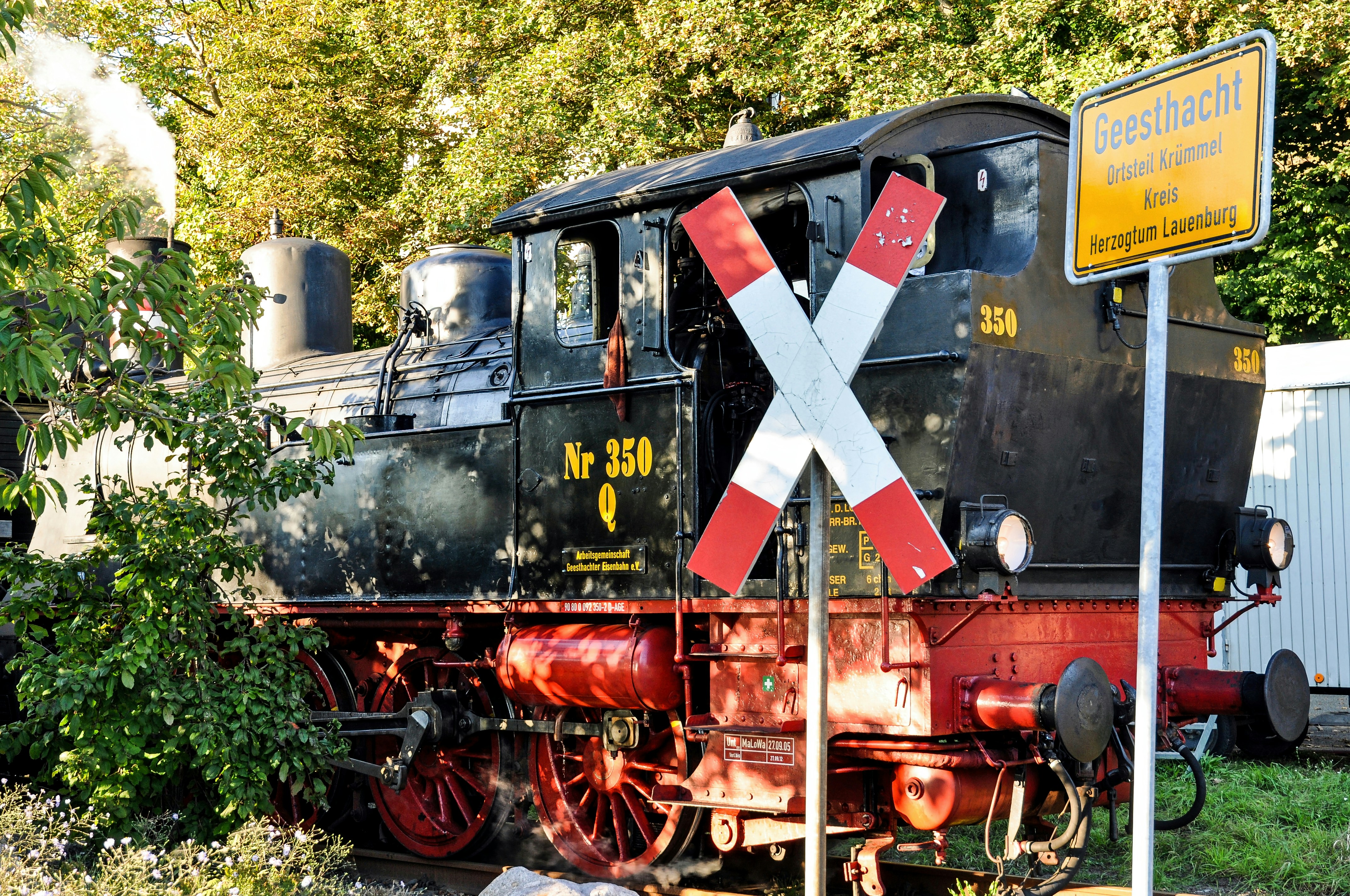 Old steam locomotive at a railway crossing.