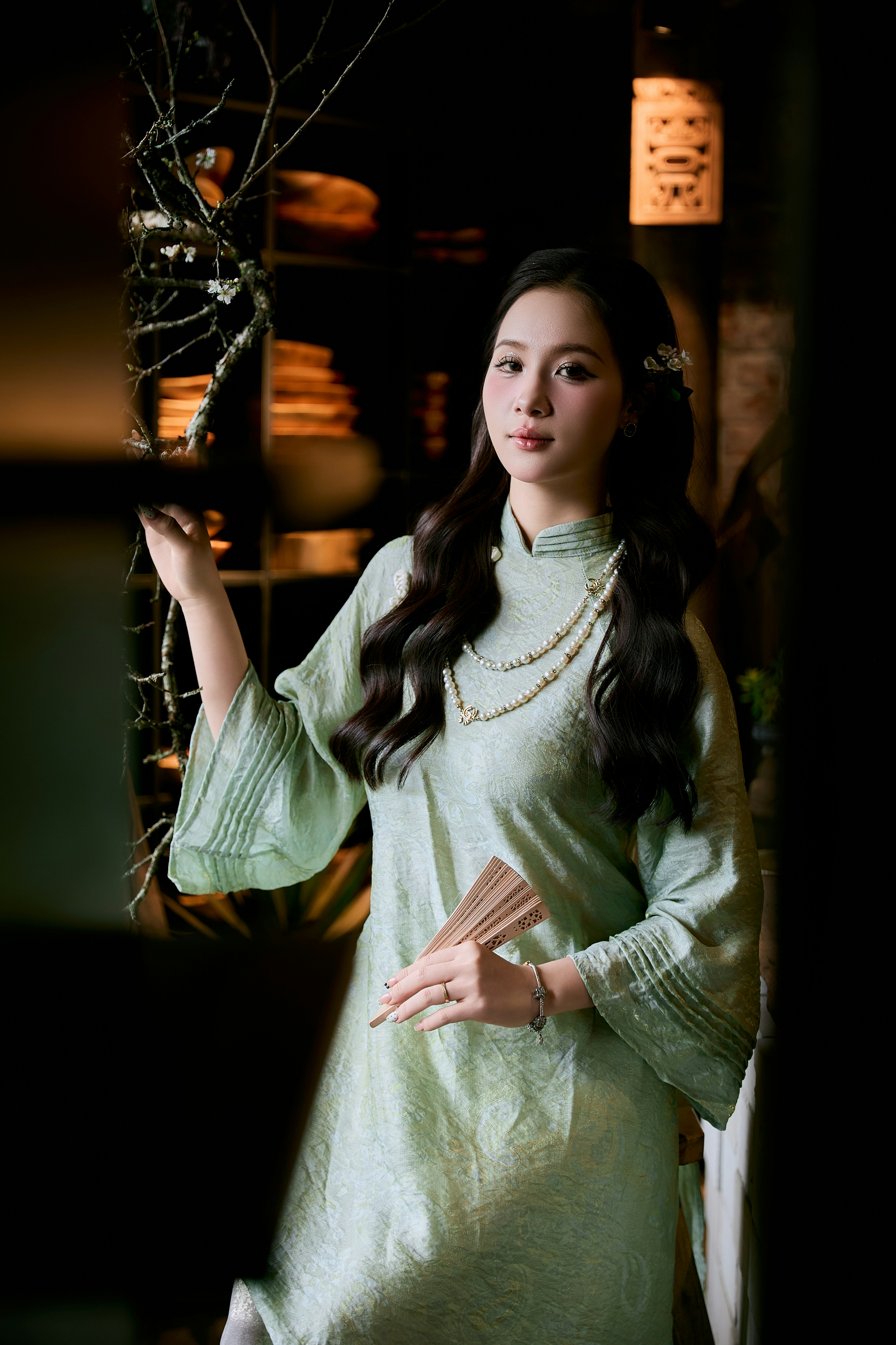Woman in traditional vietnamese ao dai holding a fan