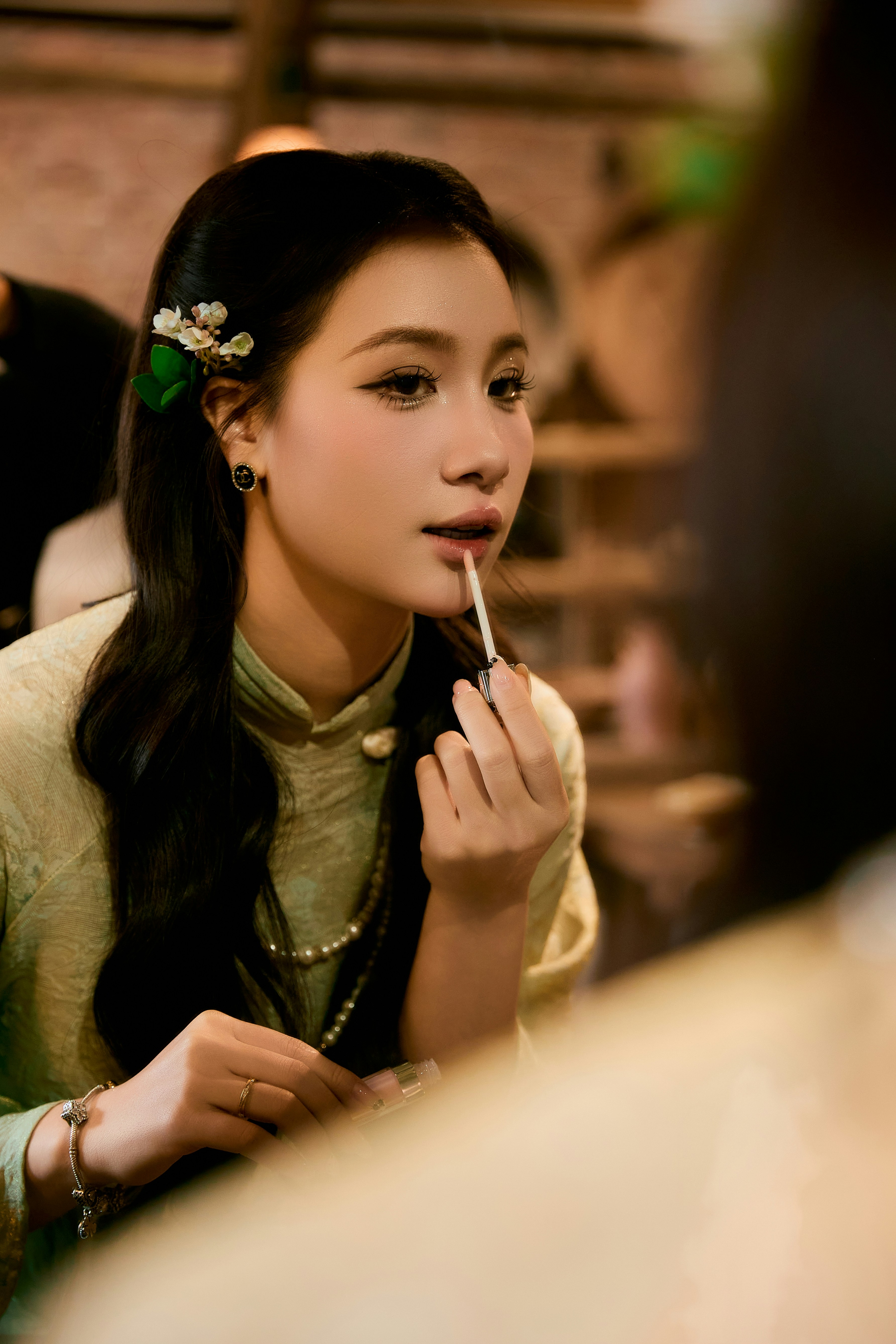 Frau, die vor einem Spiegel Lippenstift aufträgt