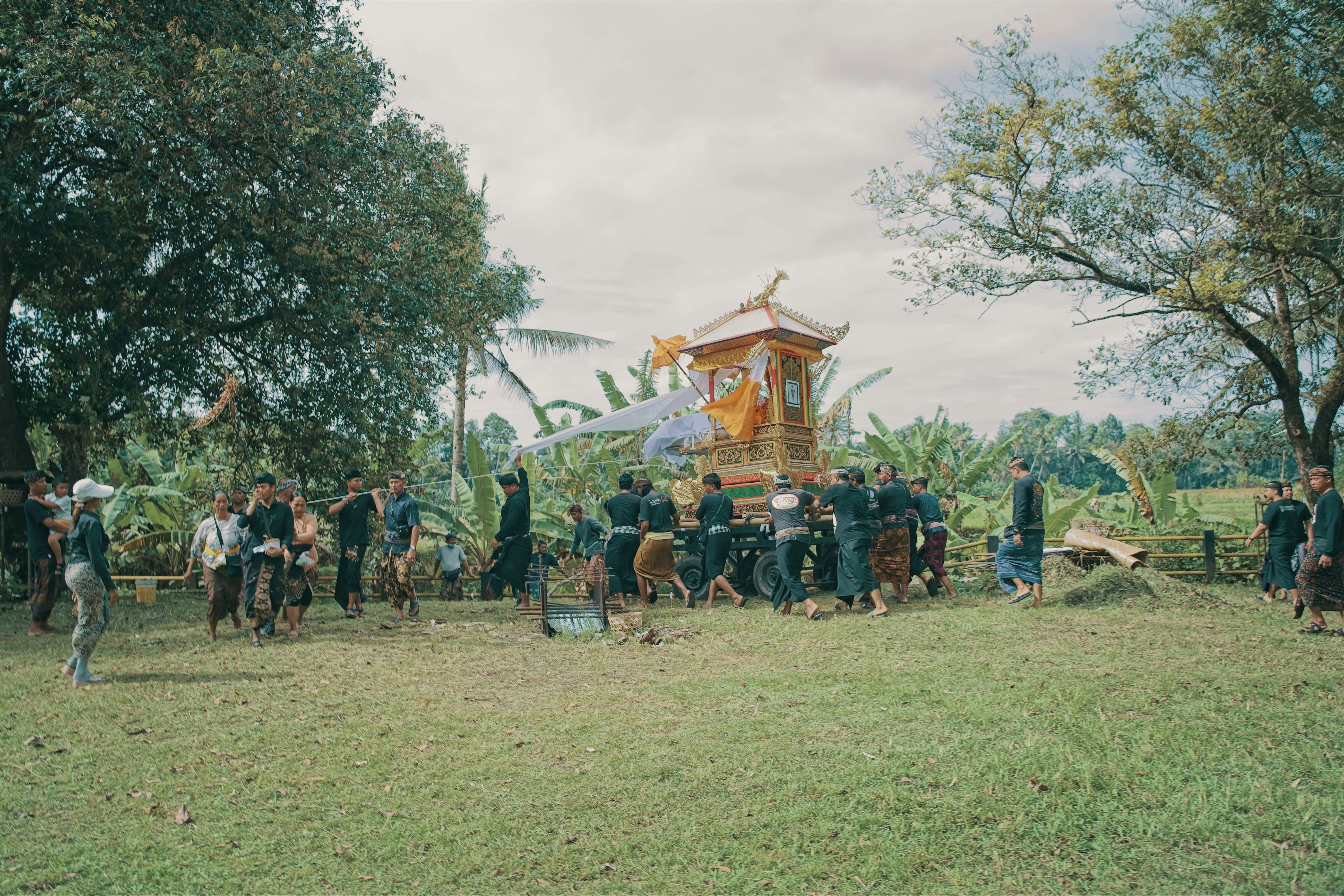 A group of people gathered around a ceremonial structure outdoors