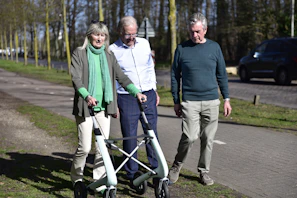 Three people with a walker on a path