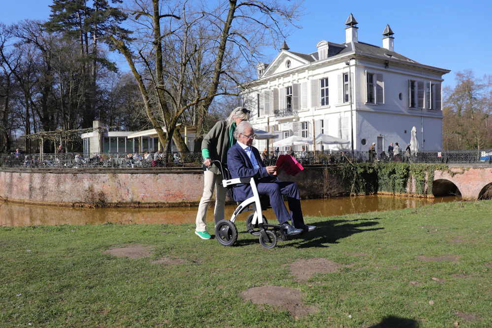 Wheelchair passenger receiving mobility assistance outdoors