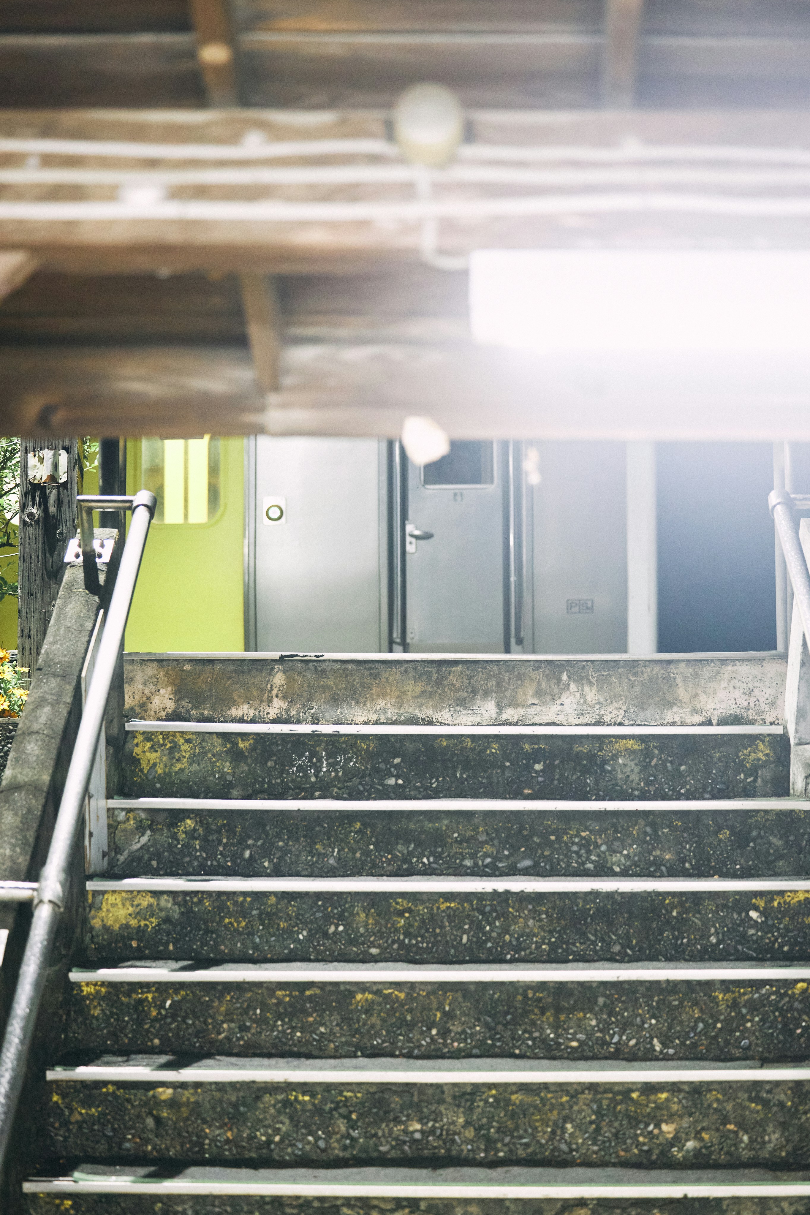 風化したコンクリートの階段は金属製の扉へと続いています。