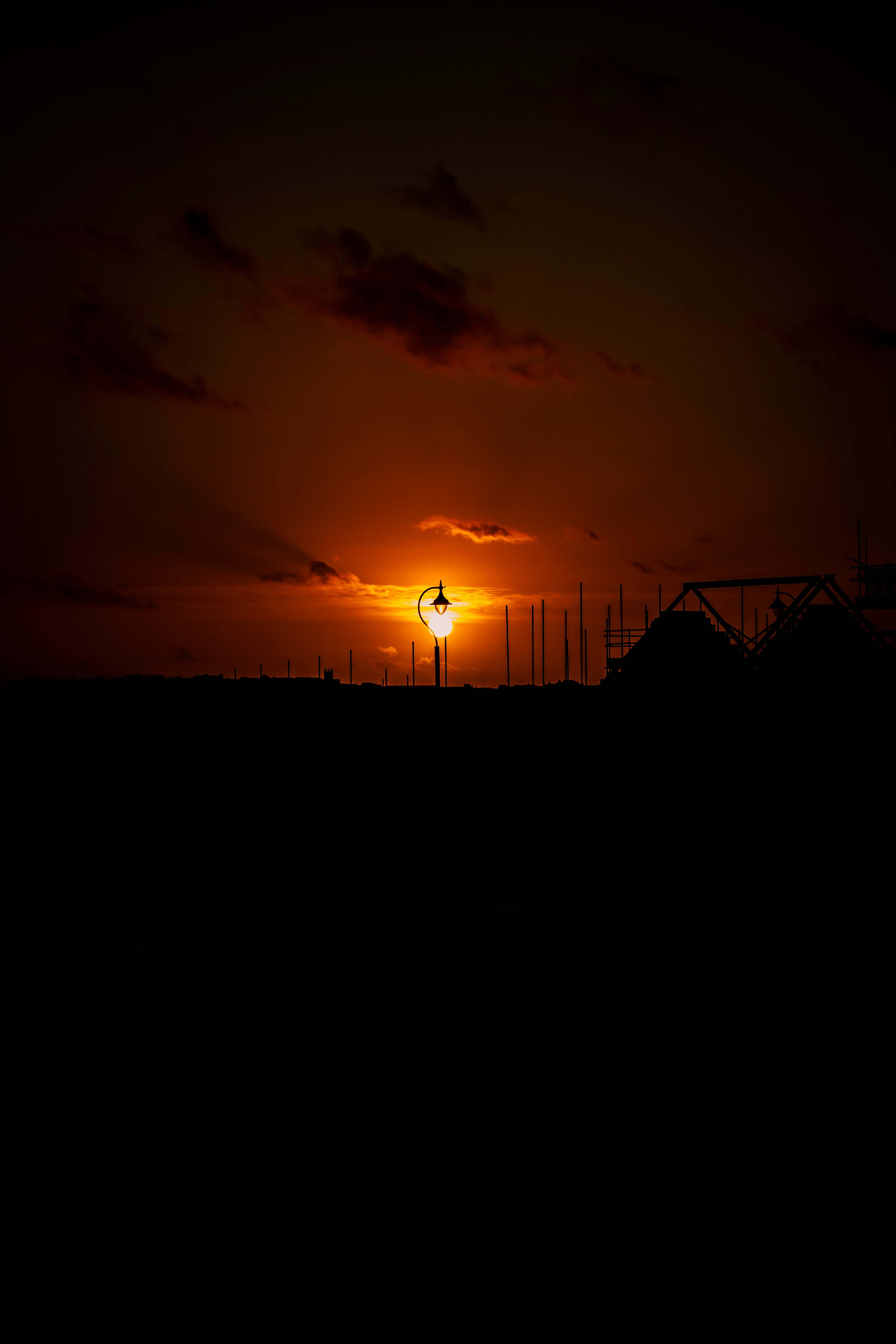 Street lamp silhouetted against a fiery sunset sky.