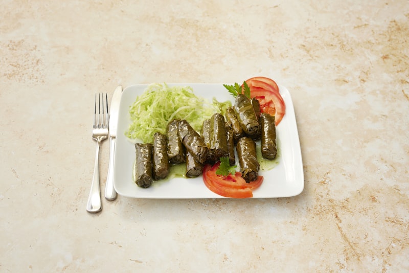 Stuffed vegetables plated with fresh herbs and tomato