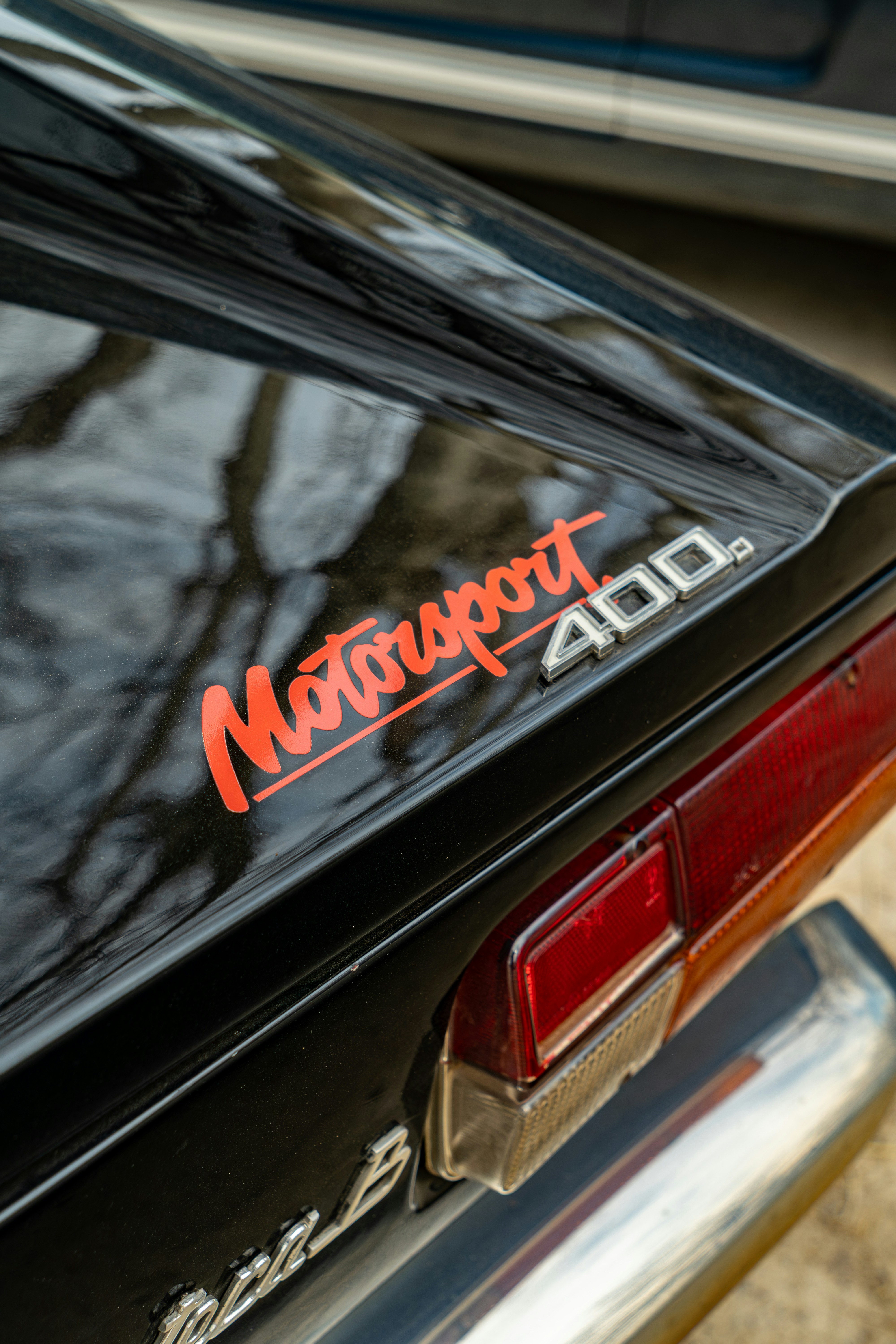 Gros plan d’un badge « motorsport 400 » sur une voiture.