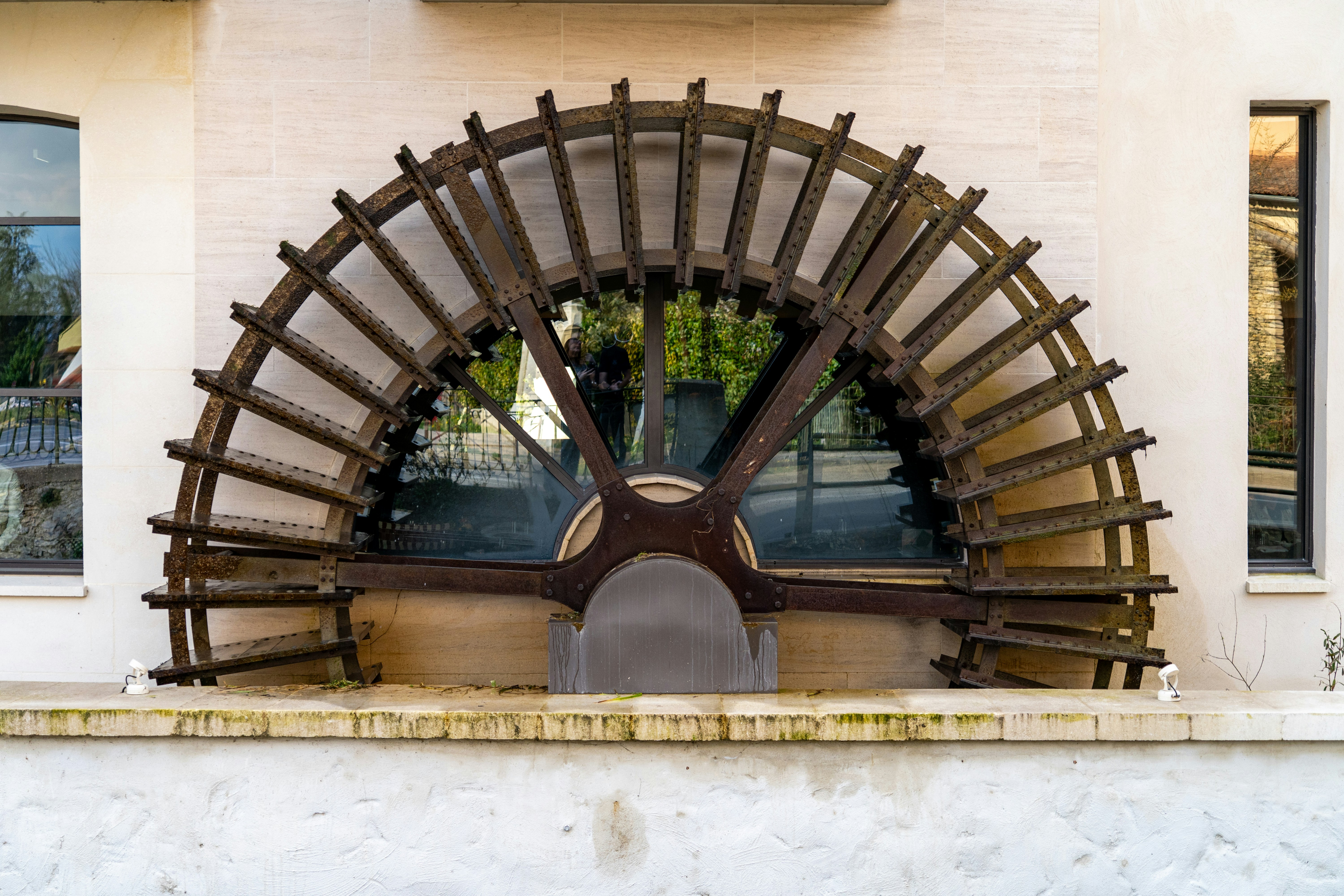 Une grande roue à eau en bois contre un bâtiment