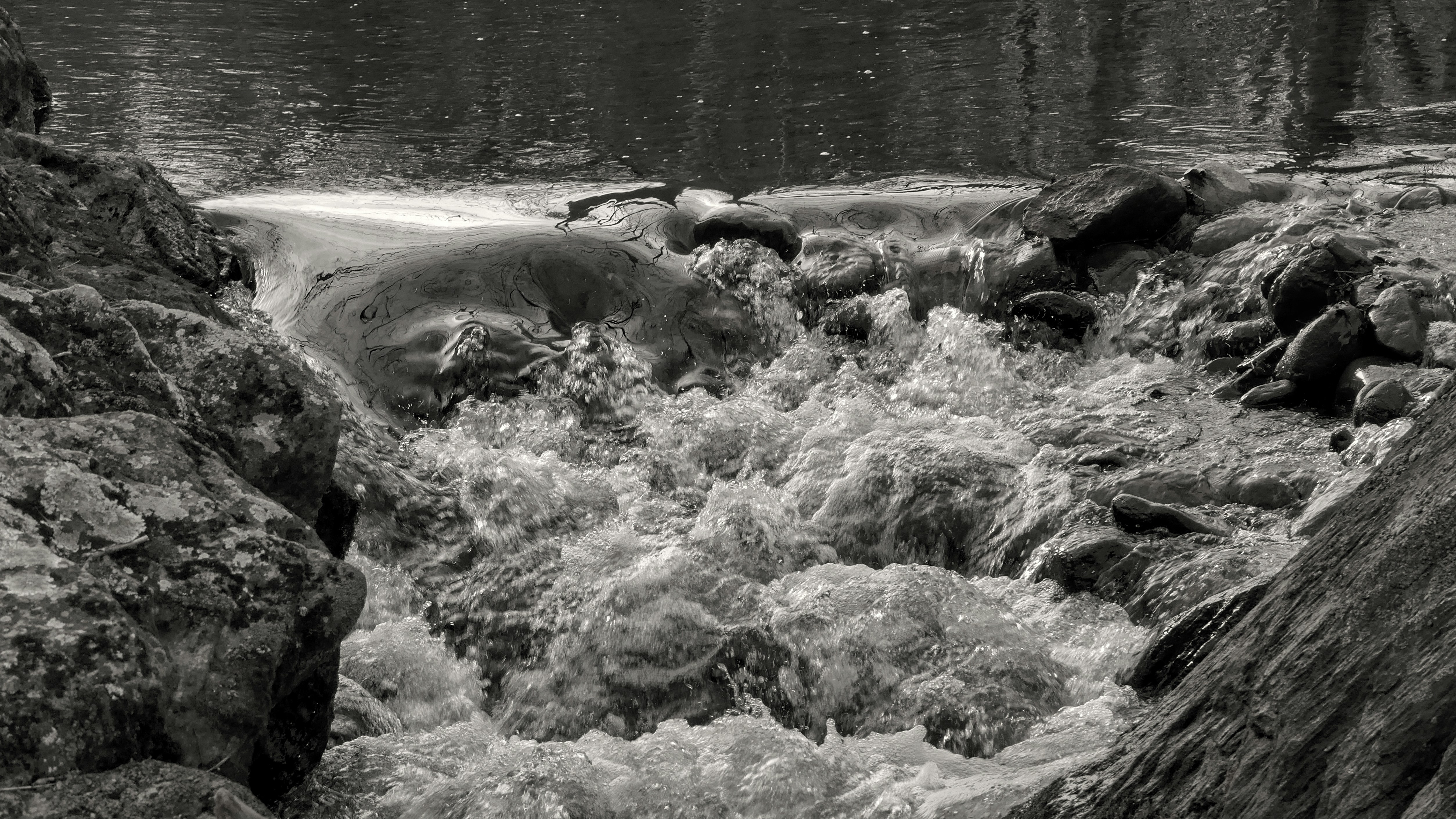 Rauschendes Wasser stürzt über Felsen in einem Bach.
