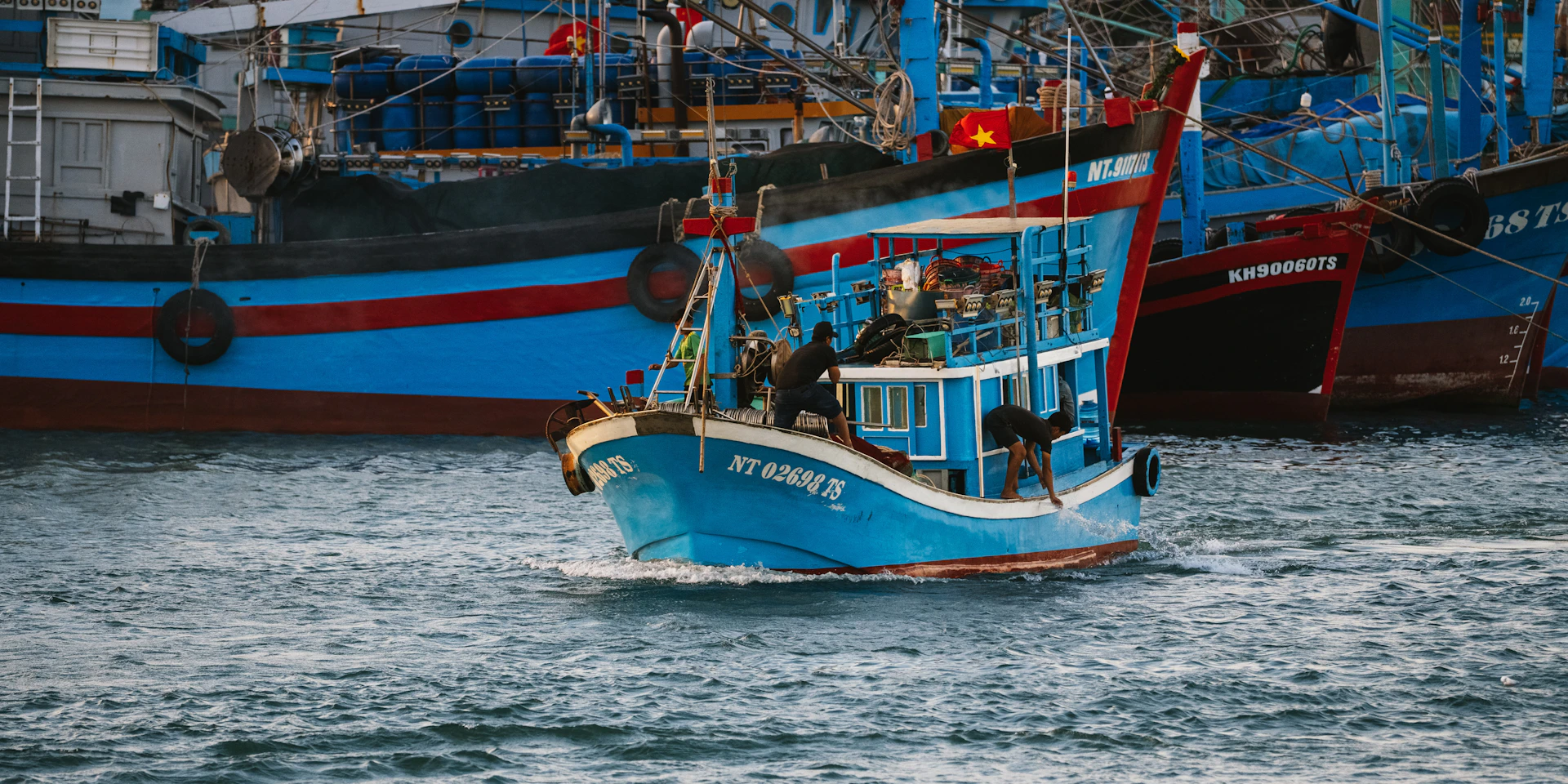 Several blue fishing boats on the water