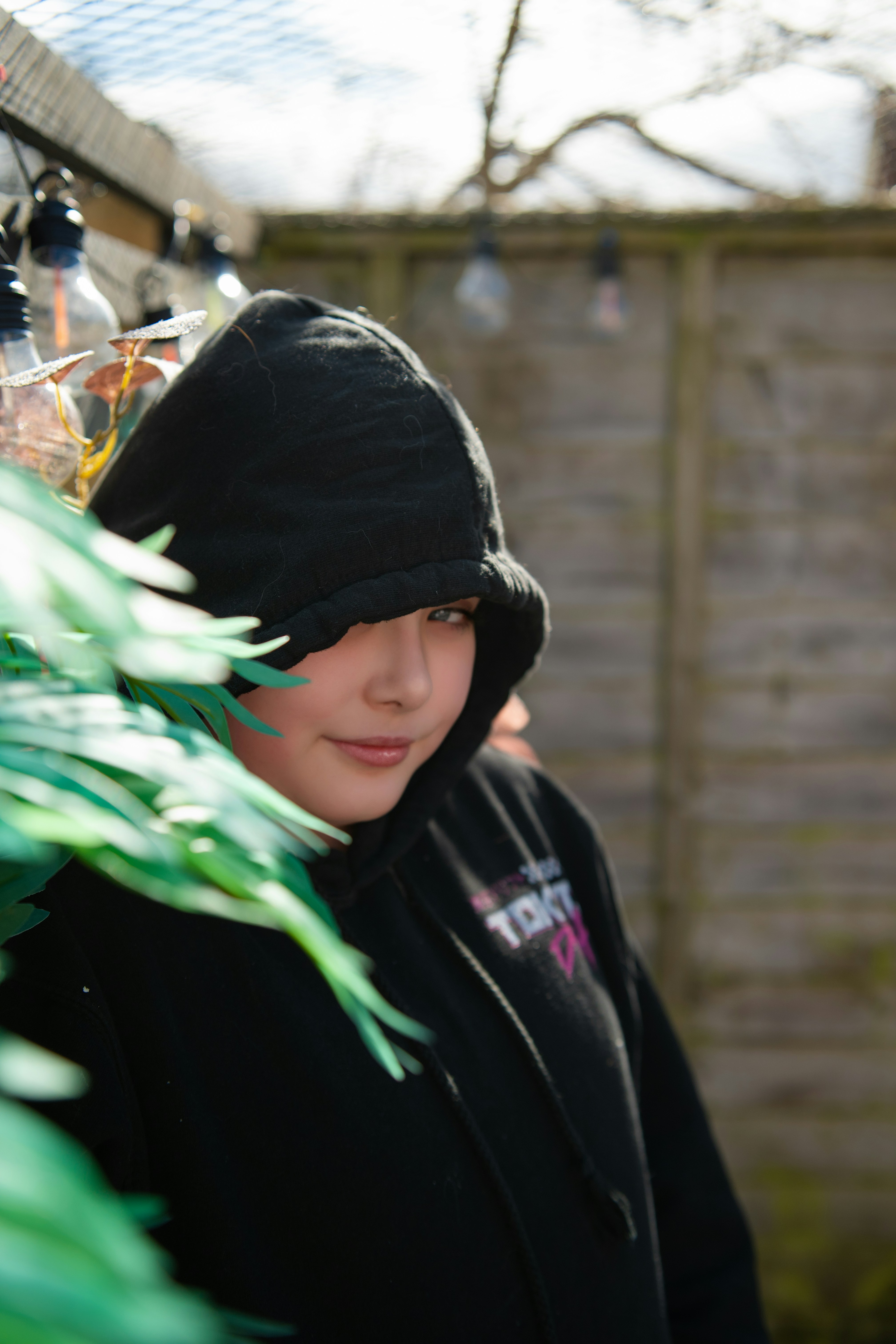 A young person in a black hoodie outside