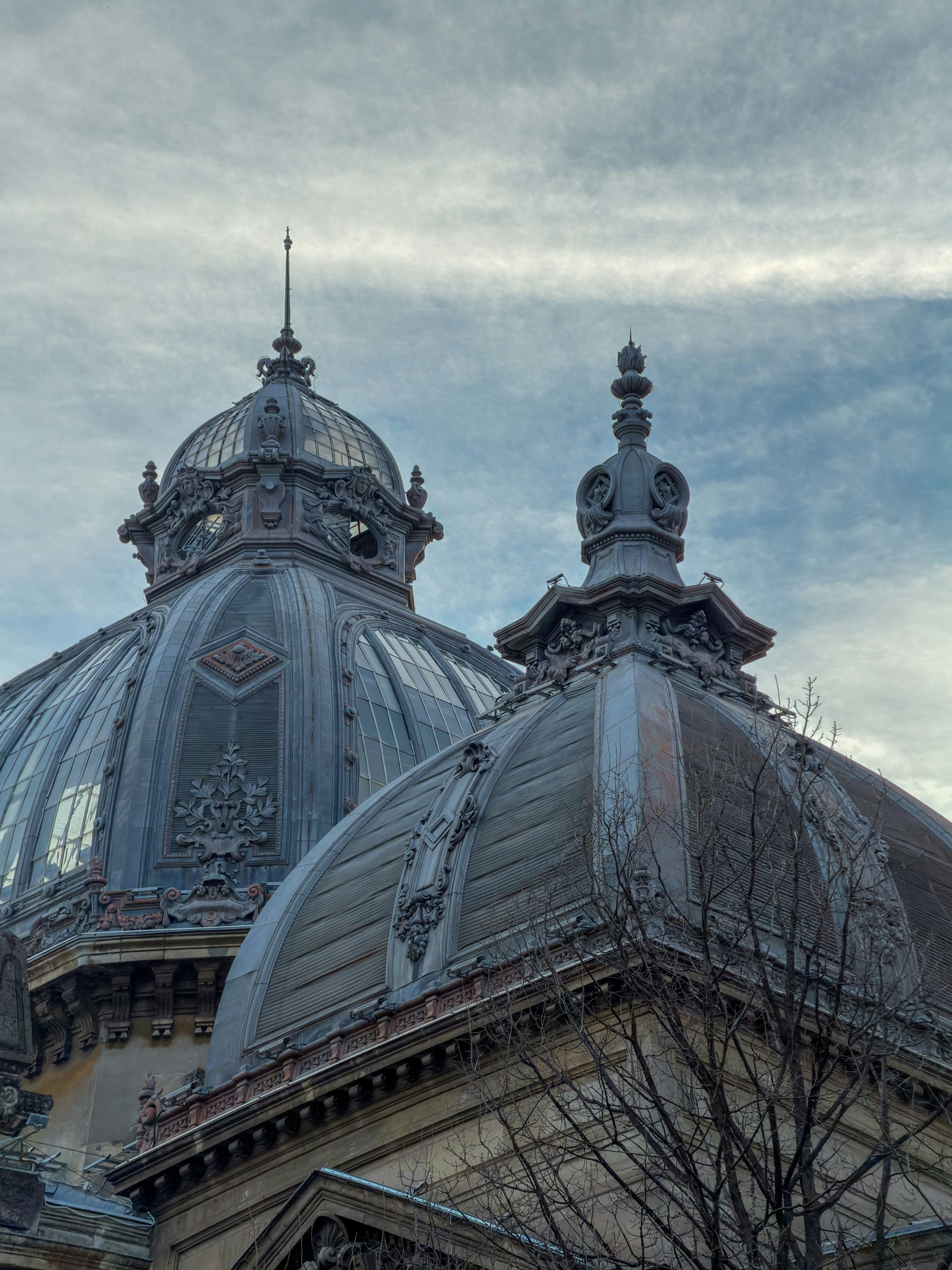 Ornate domes of a grand building against a cloudy sky