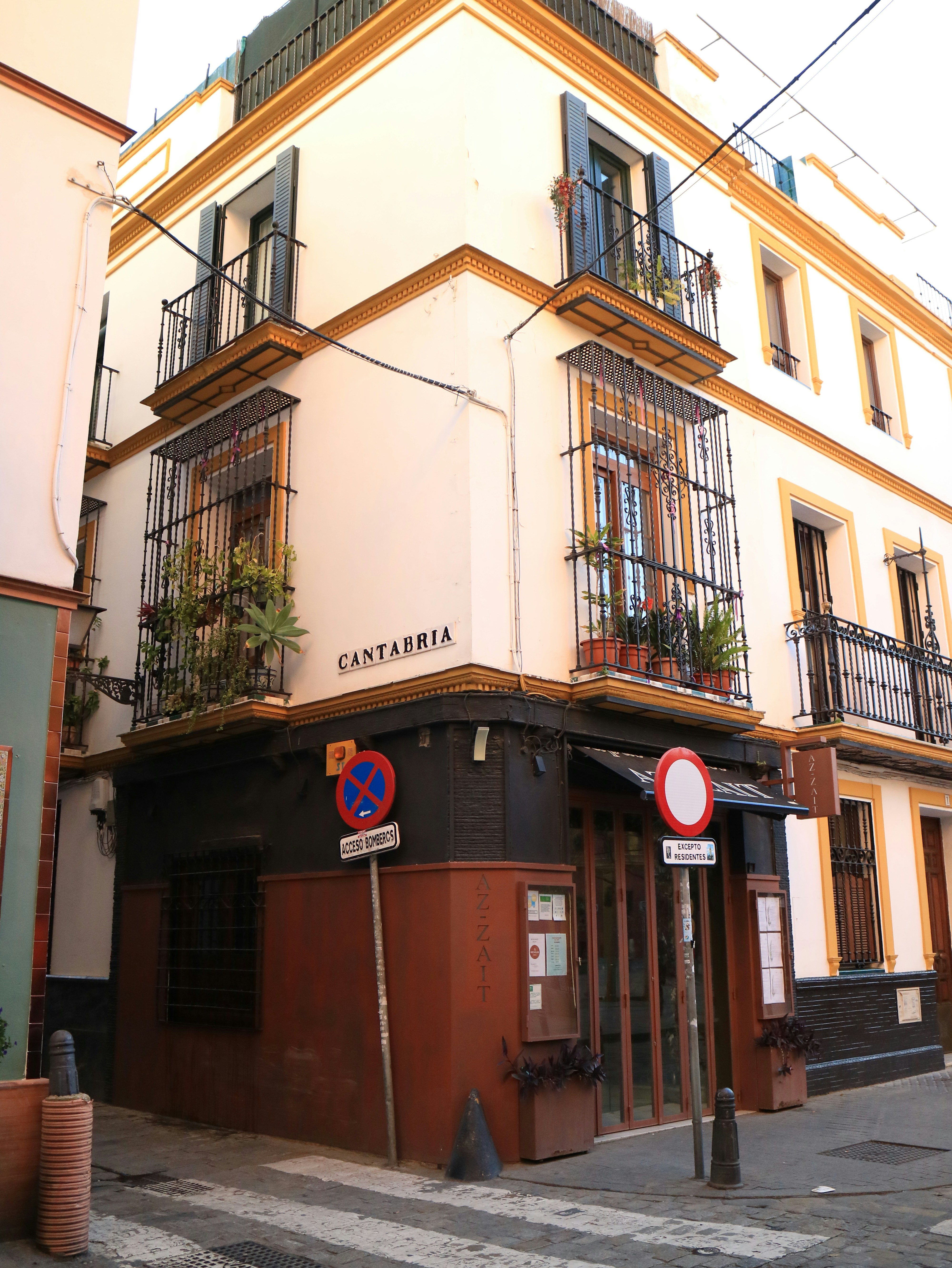 Edifício de canto com varandas e detalhes em ferro forjado.