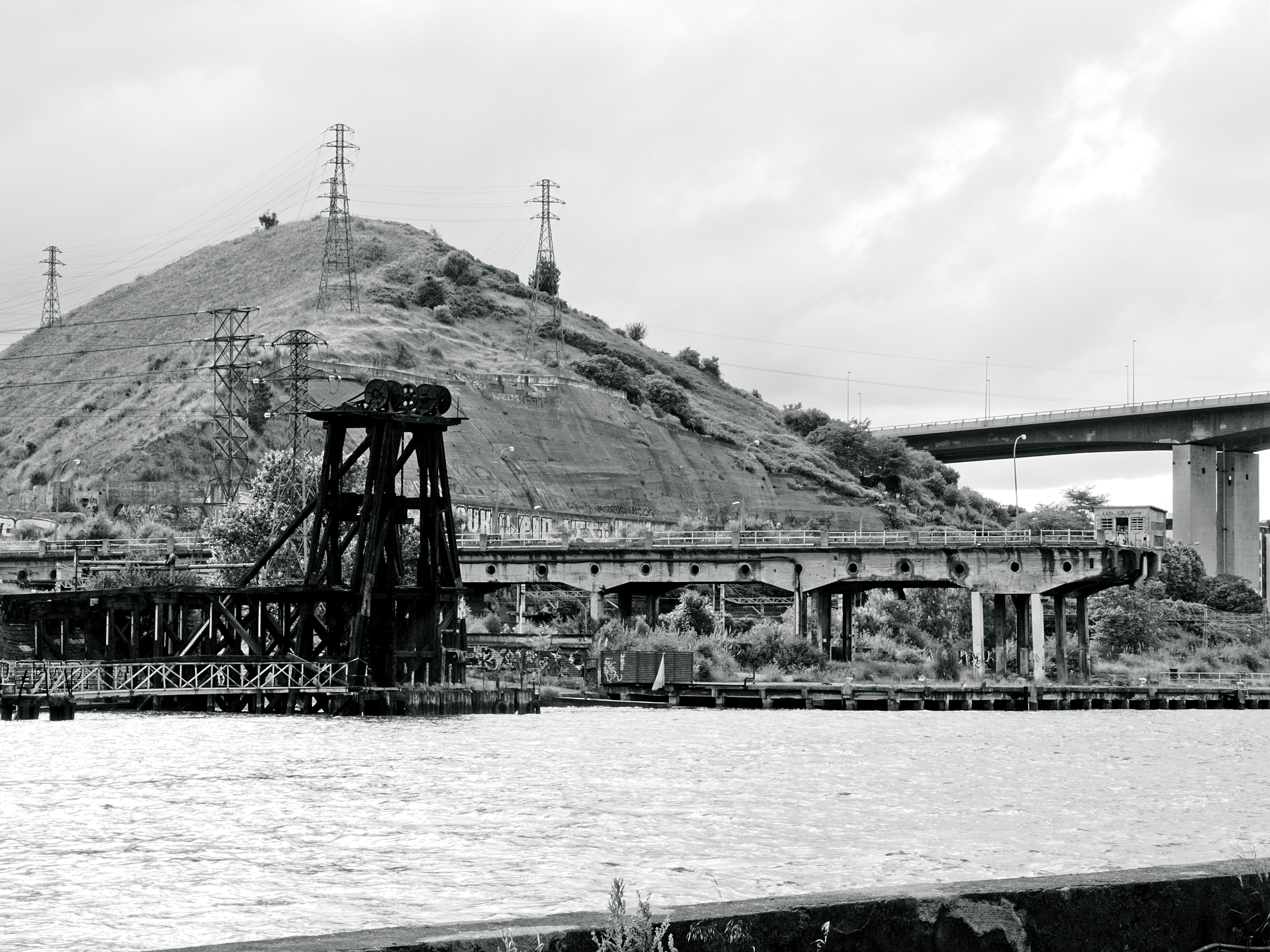 Encosta com estruturas industriais e ponte sobre a água