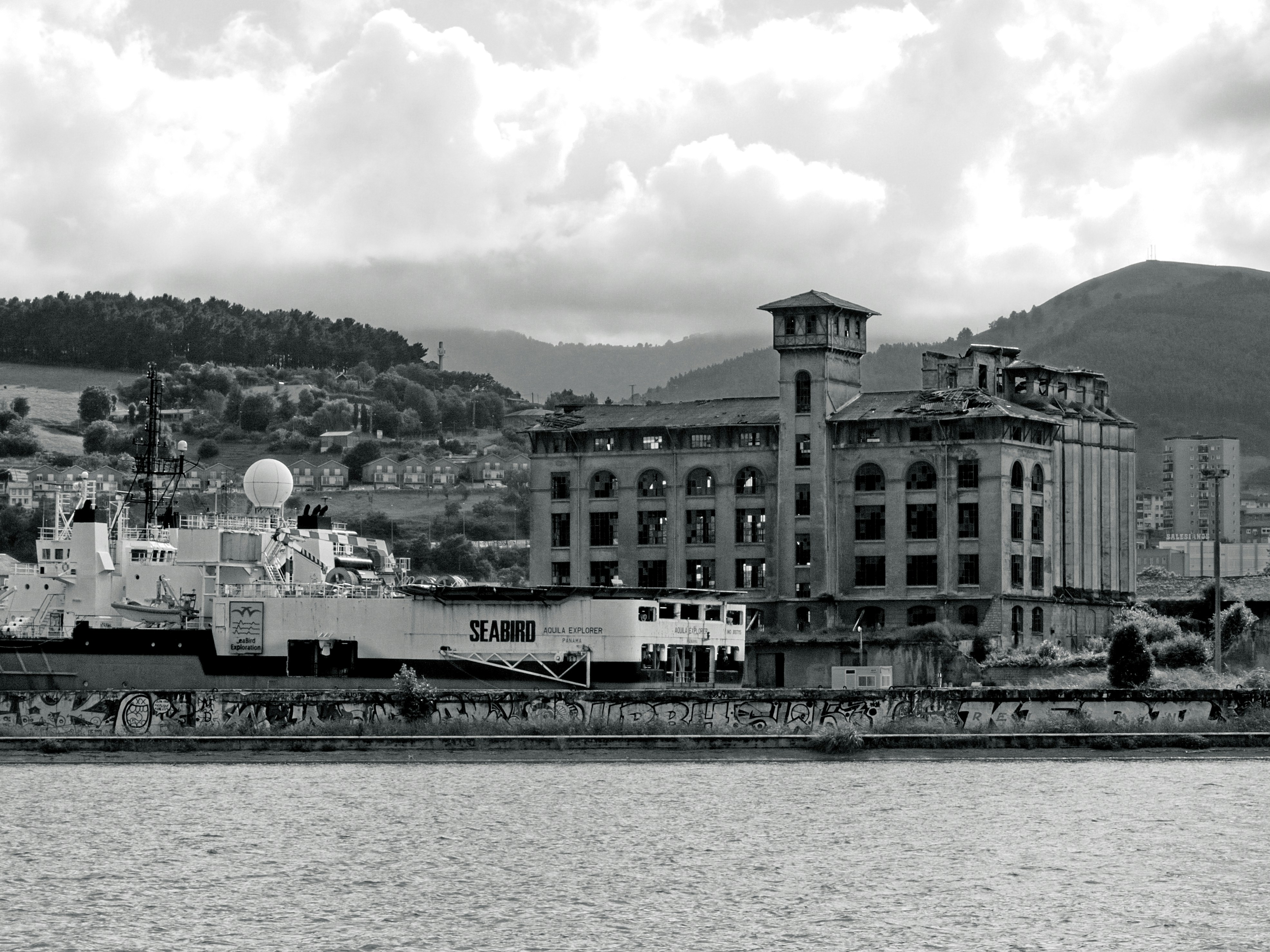 Prédios industriais e um navio à beira d'água