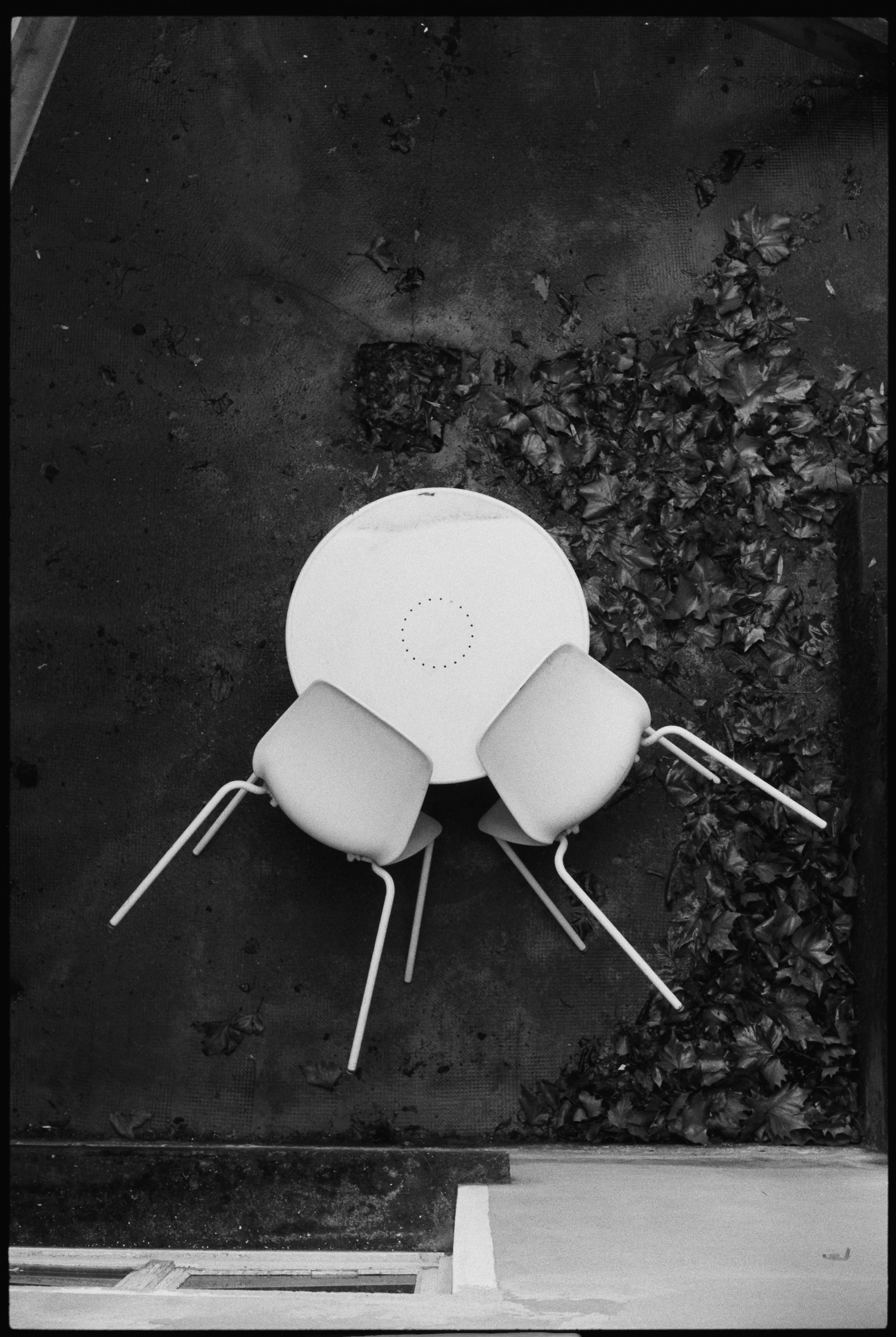 暗い表面の上に椅子が二脚とテーブルが置かれている。