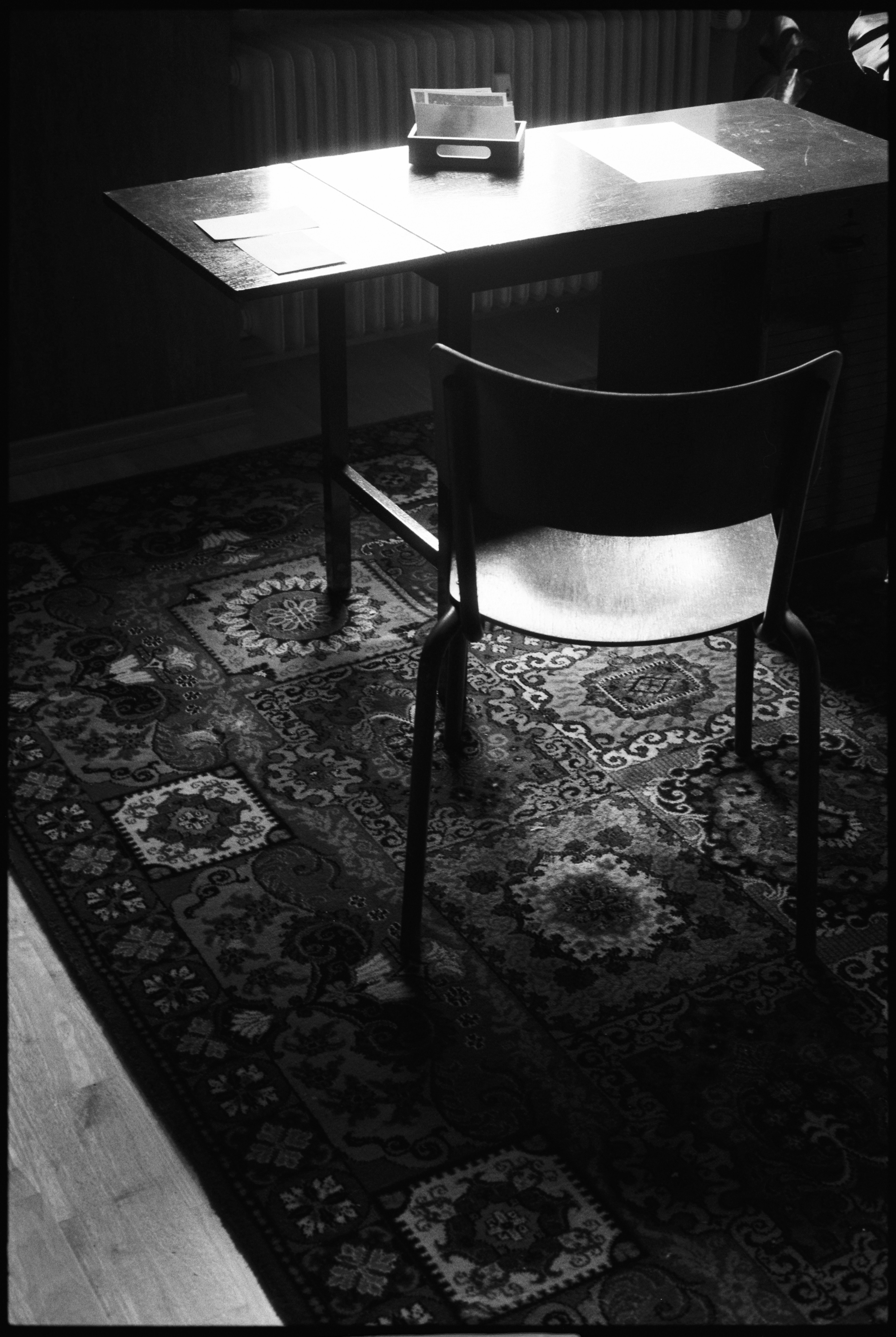 柄のあるラグの上に椅子がテーブルの前に置かれている。