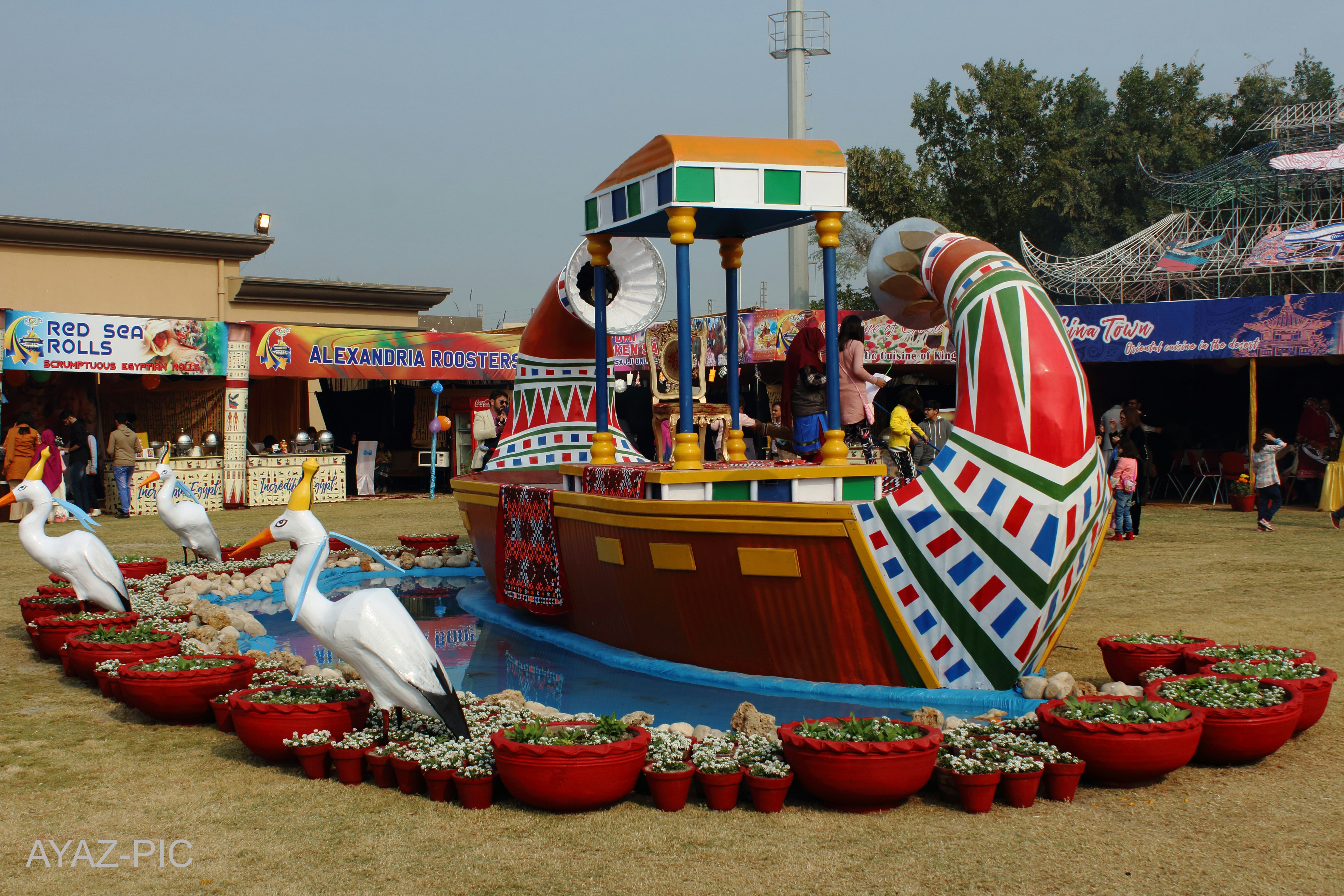 Decorative boat with bird statues and potted plants