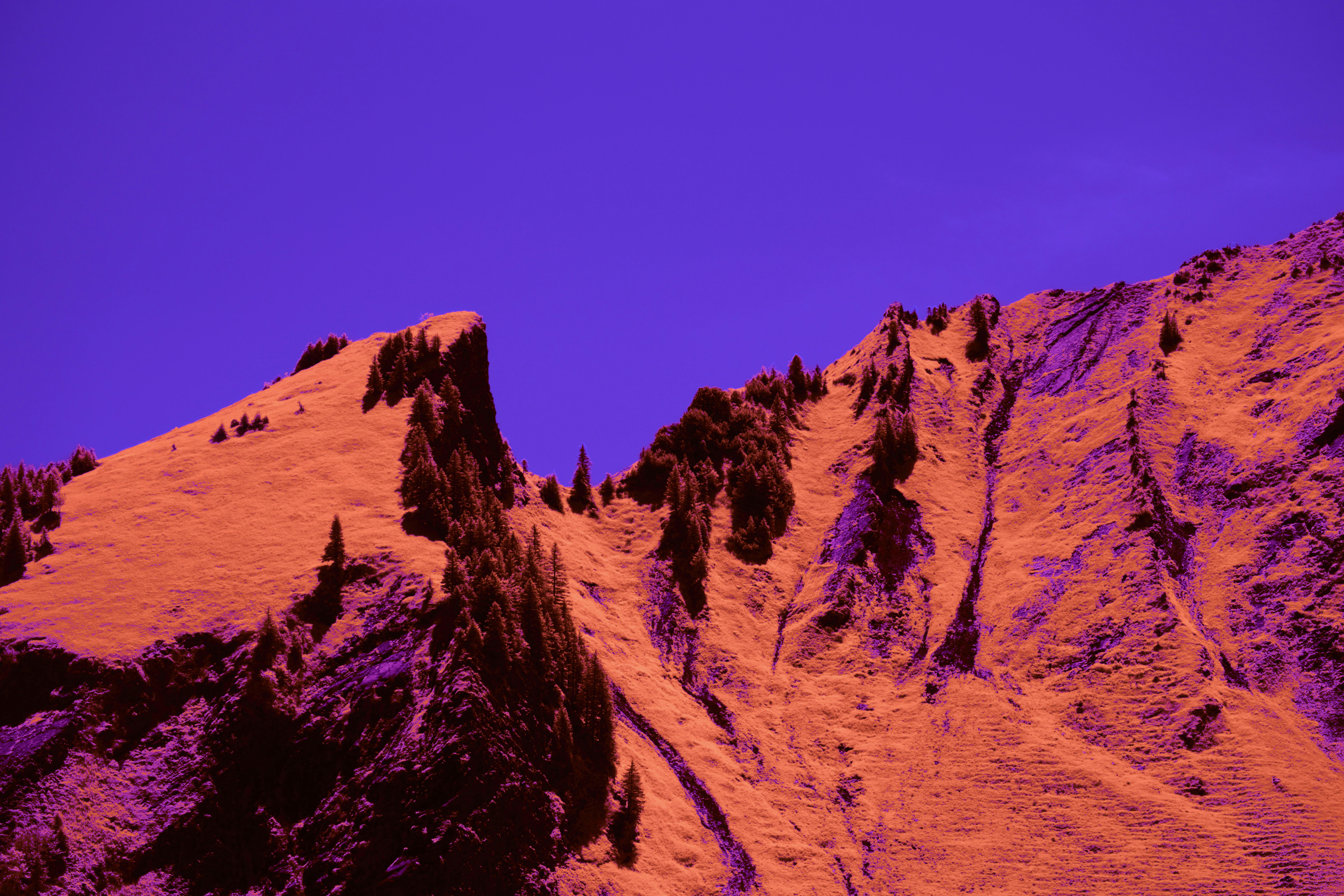 Una montaña naranja se desploma contra un cielo púrpura