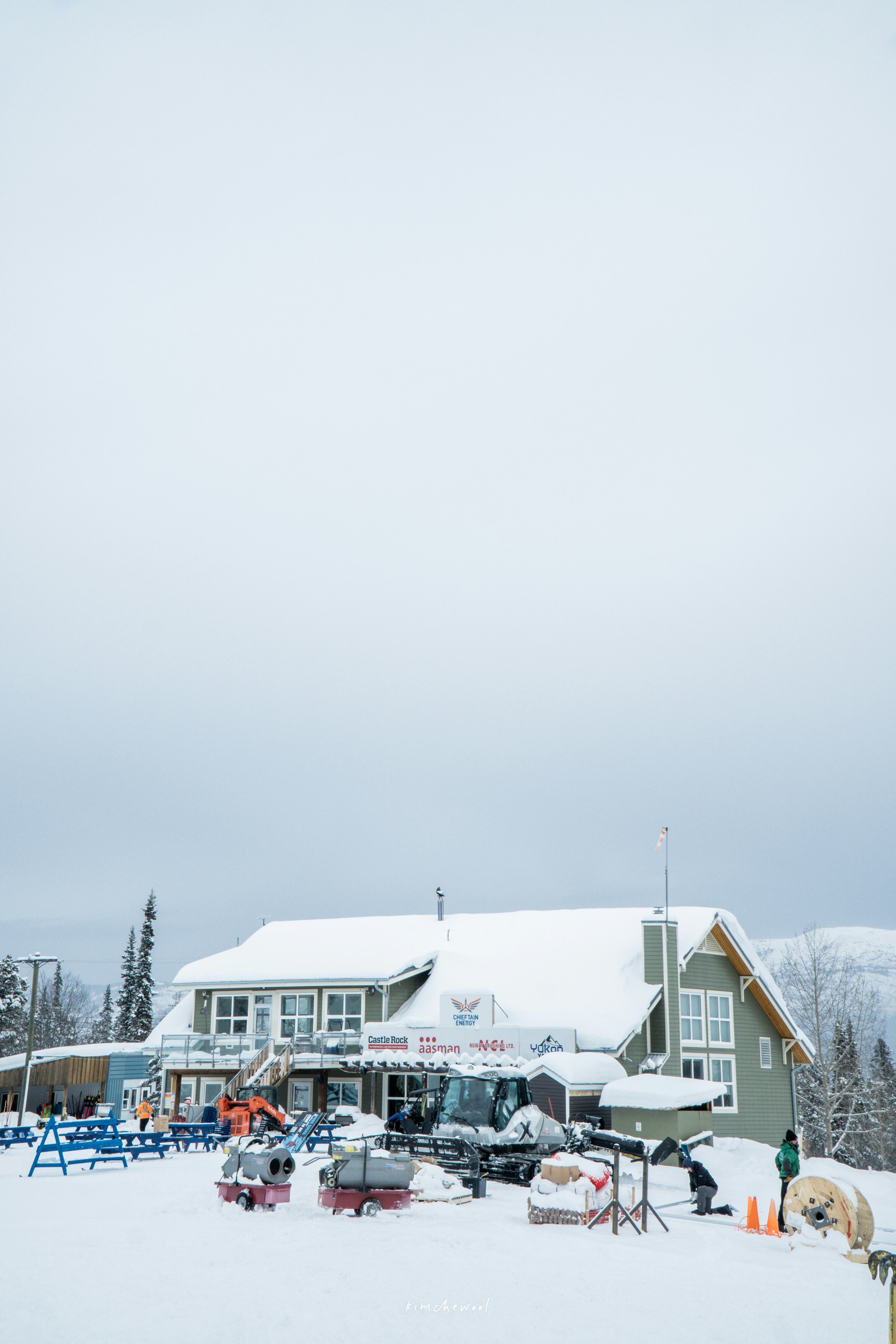 Un edificio cubierto de nieve con asientos al aire libre