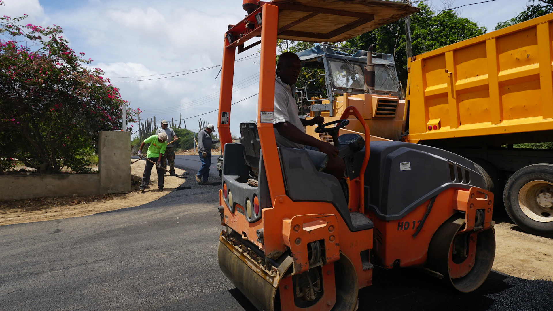 Man driving a steamroller on a paved road