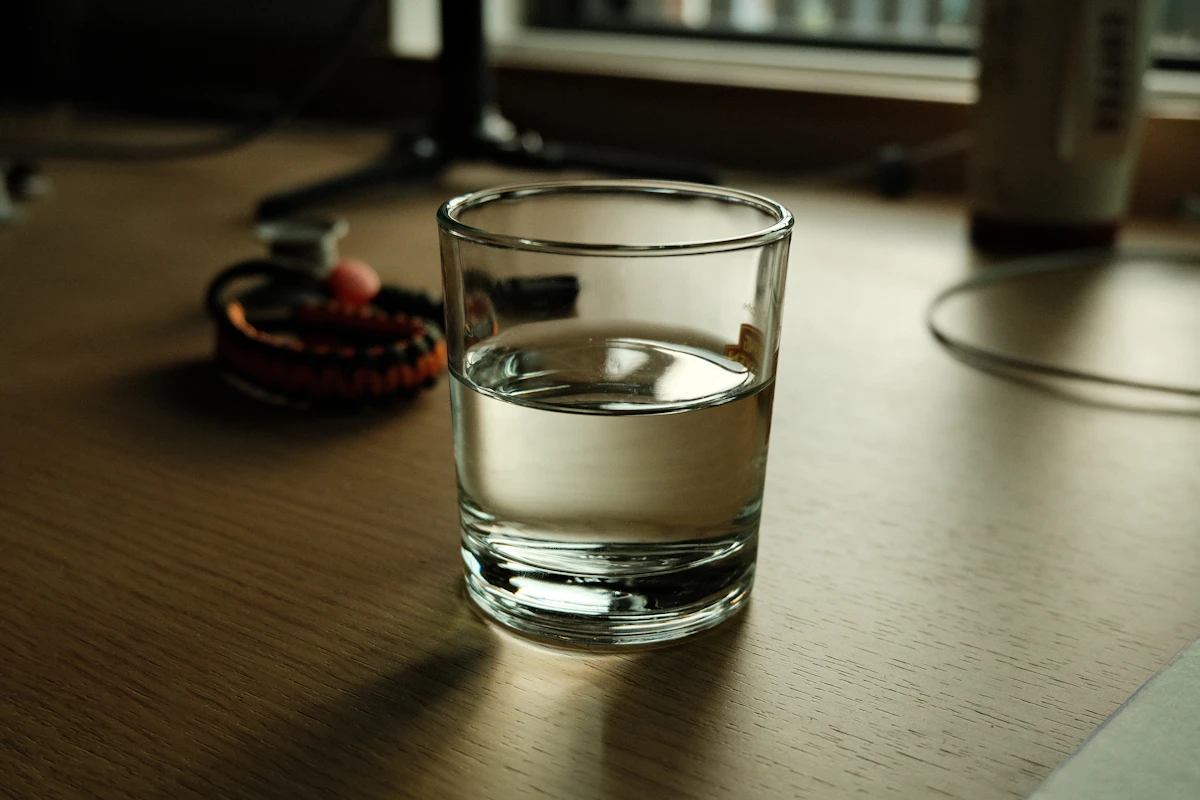 A glass of water on a wooden desk