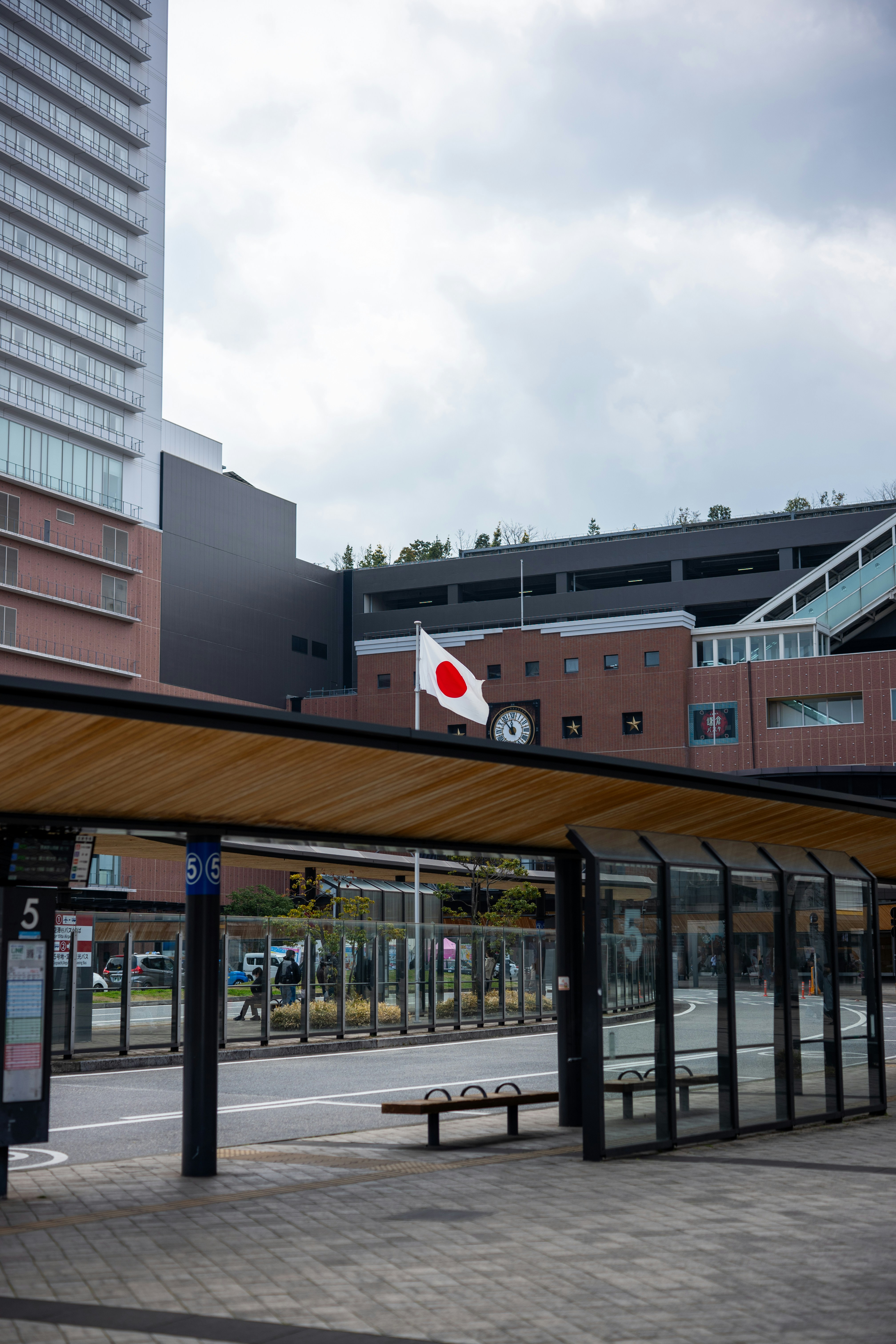 Die japanische Flagge weht über einem modernen Busbahnhof.